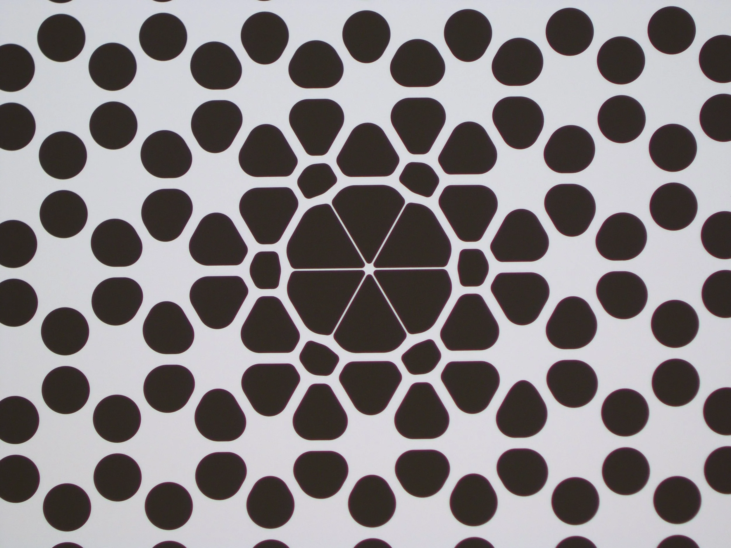 A black and white optical illusion pattern resembling a series of black dots and hexagons that create a tunnel-like effect.