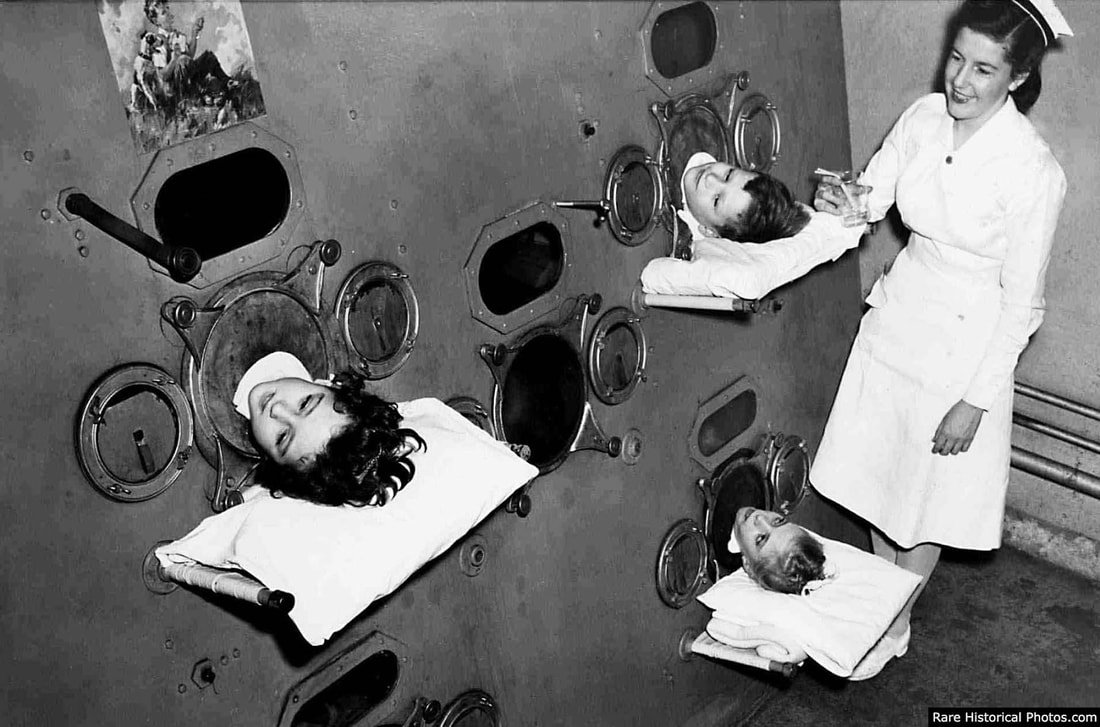 Children in an iron lung, 1950, before the advent of a vaccine. 3 children's heads poke out of the iron lung while a nurse is smiling and tending to them.