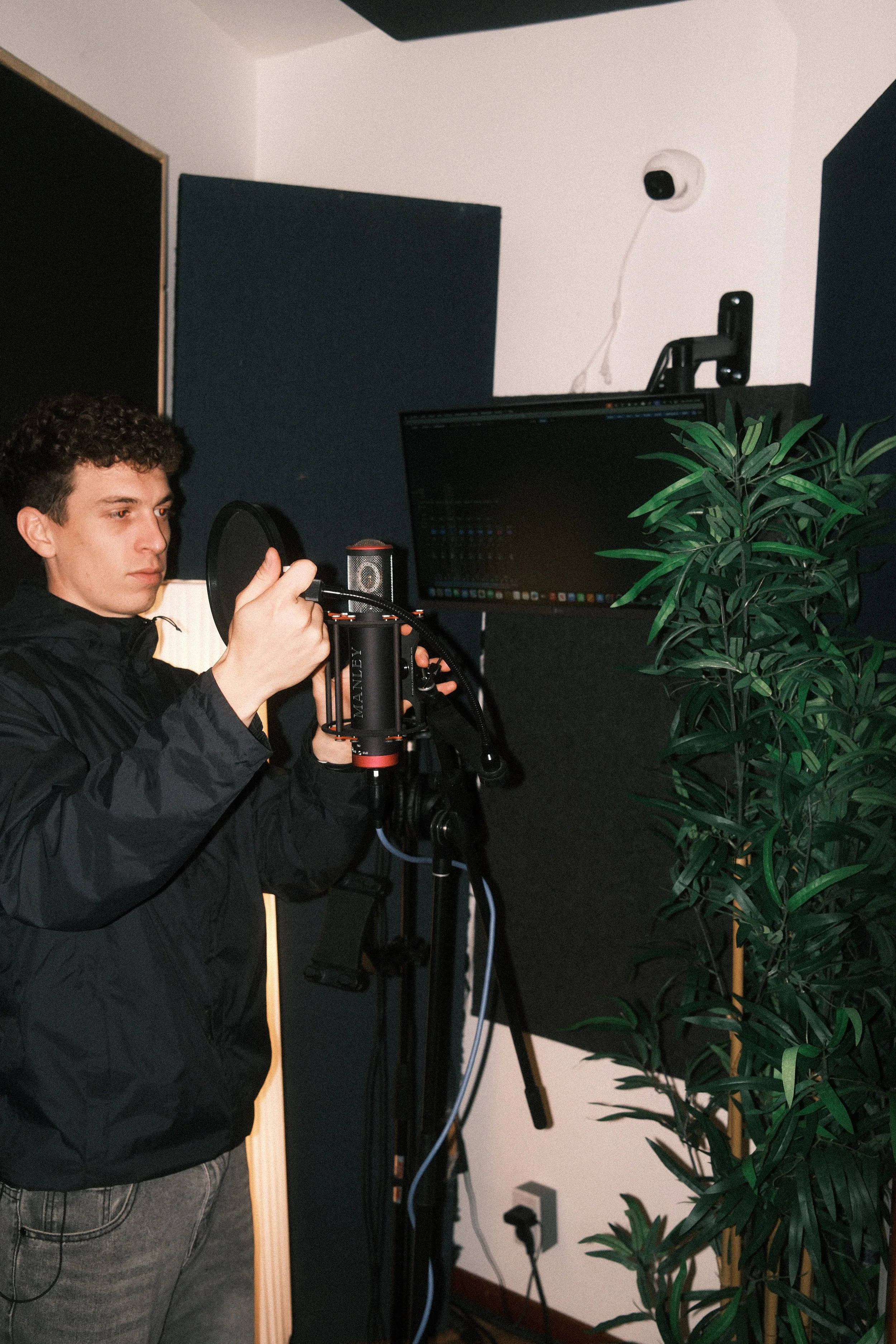 Le directeur du Studio Agora Théo Bousquet en train de mettre en place un micro et un anti-pop pour l'enregistrement d'une voix off.