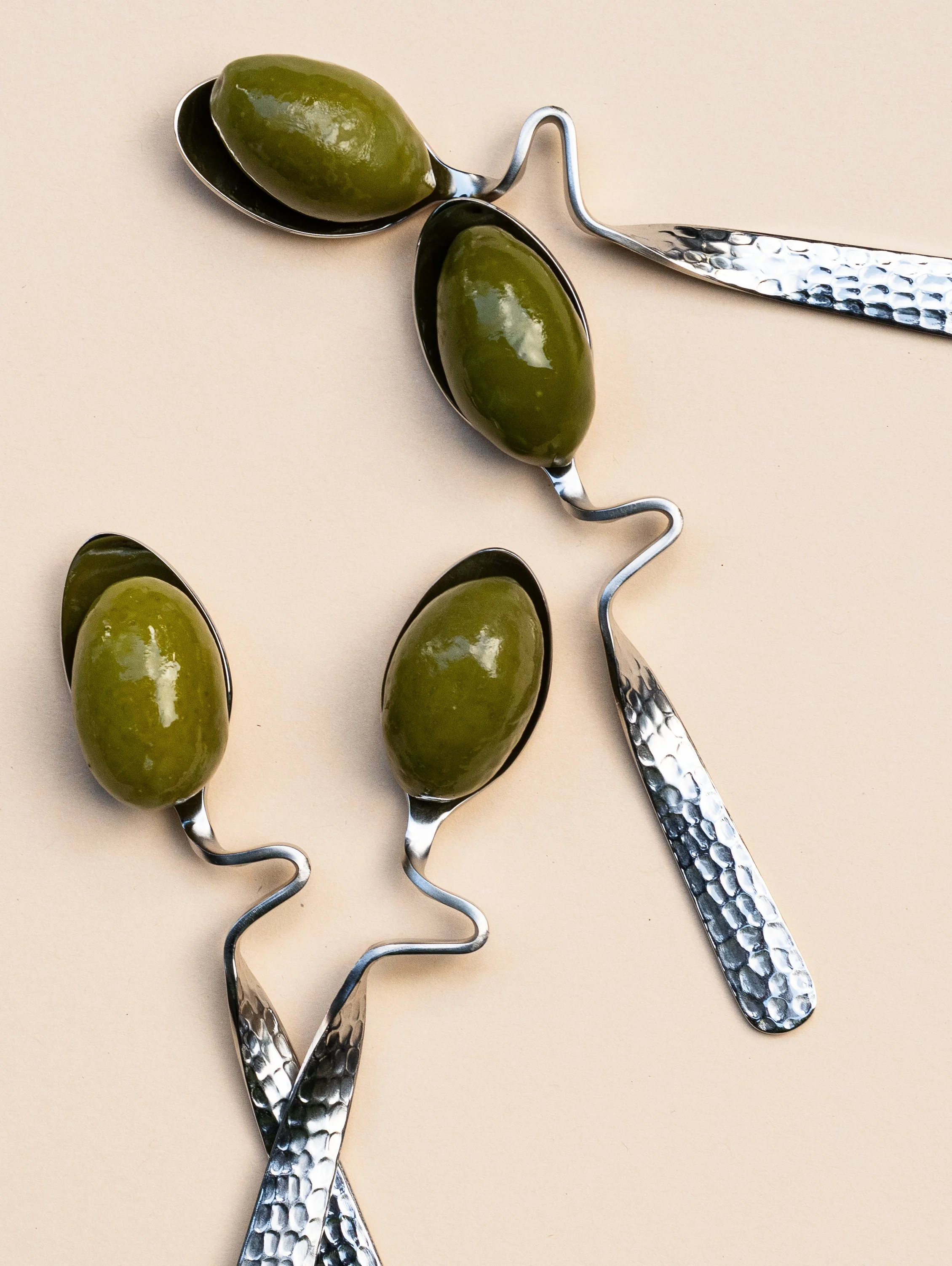 Drie ijsstokjes met groene ijsblokjes op een beige achtergrond.