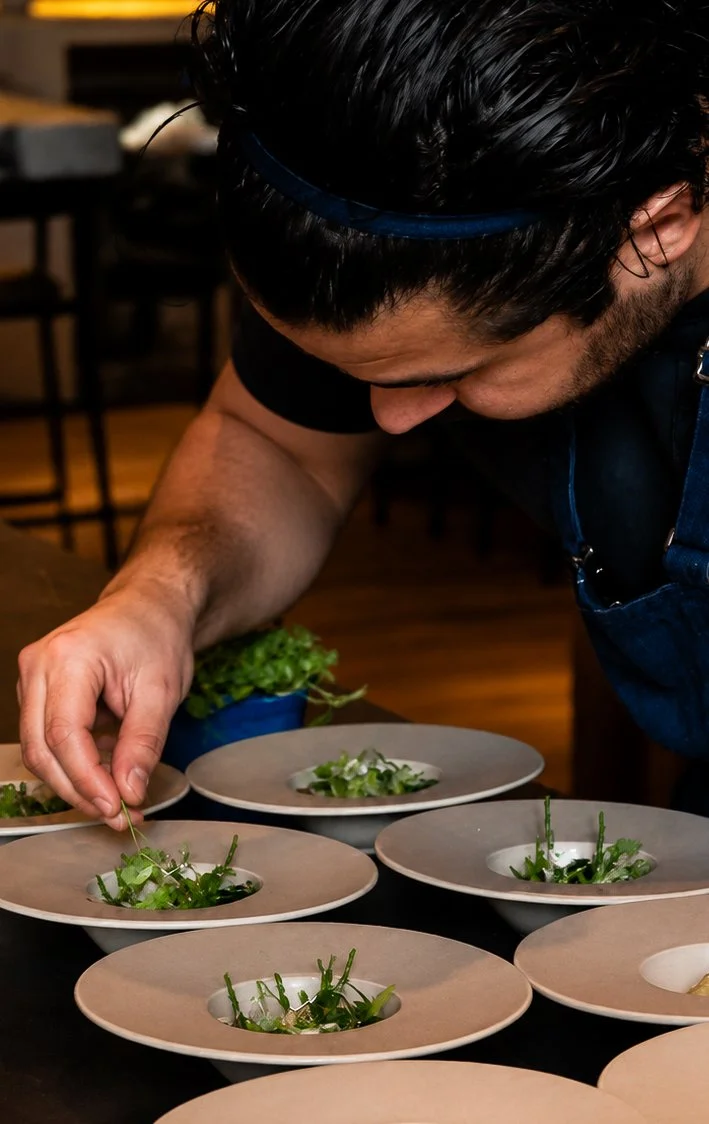 Chef plant salade op borden in een keuken of restaurant.