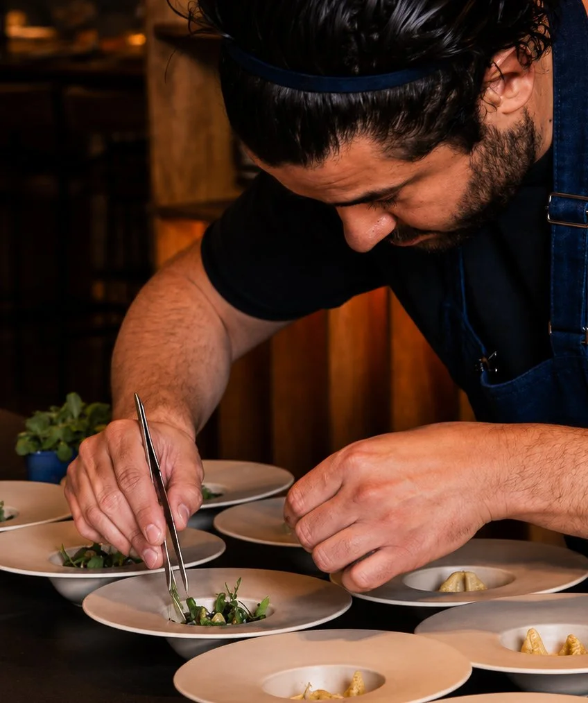 Vrouw die fijnproevertjes serveert op borden in een restaurant.