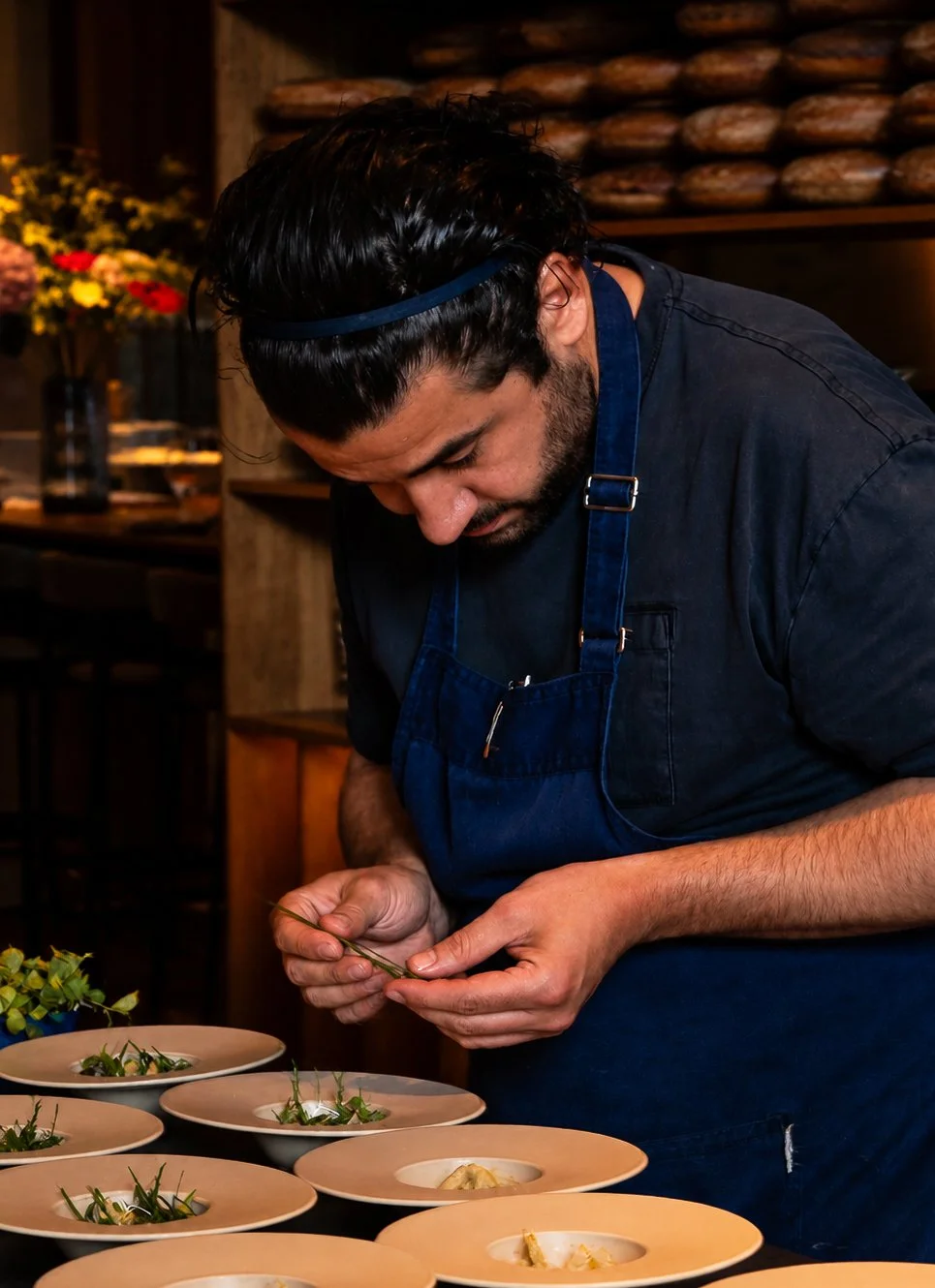 Koks bereidt gerechten voor met planten op borden in een restaurant.