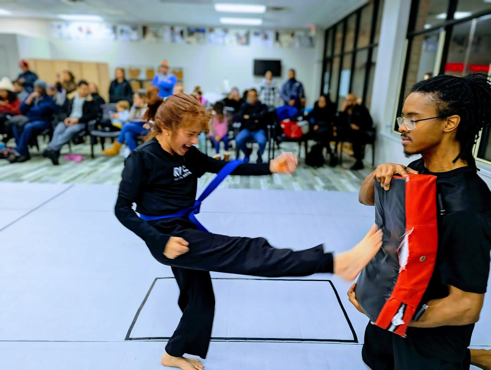 Karate girl throwing a front push kick.jpg