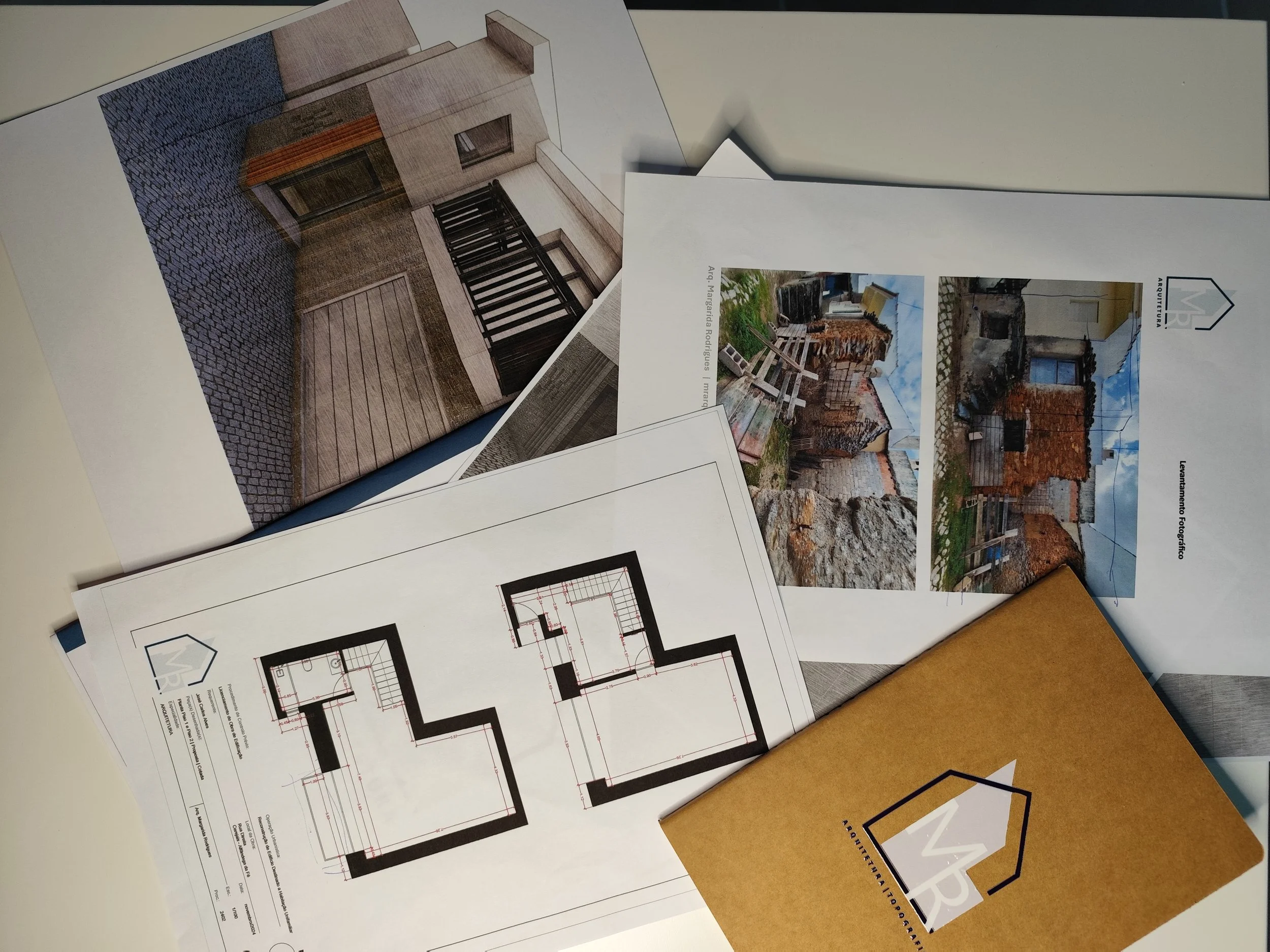 Maquete de projeto de construção com plantas arquitetônicas, fotos de obras de reforma e orçamento, com materiais para planejamento de obra.