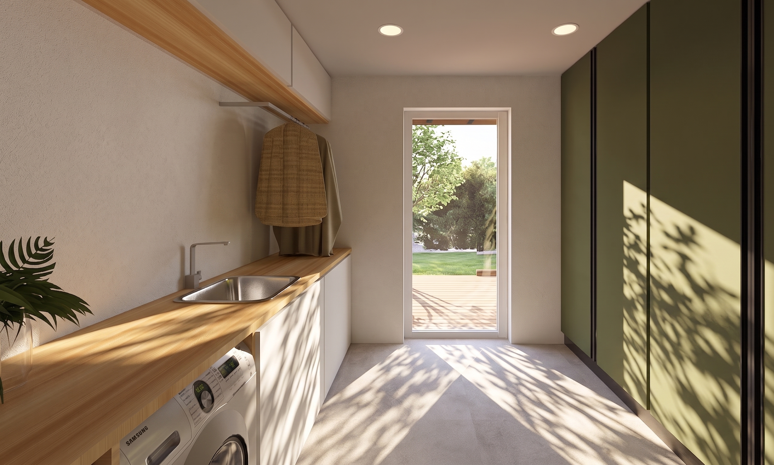 Lavanderia moderna com bancada de madeira, máquina de lavar Samsung, pia em aço inox, armários verdes em latas, porta de vidro que dá para um jardim com árvores e grama, iluminação embutida no teto e sombras de folhas na parede.