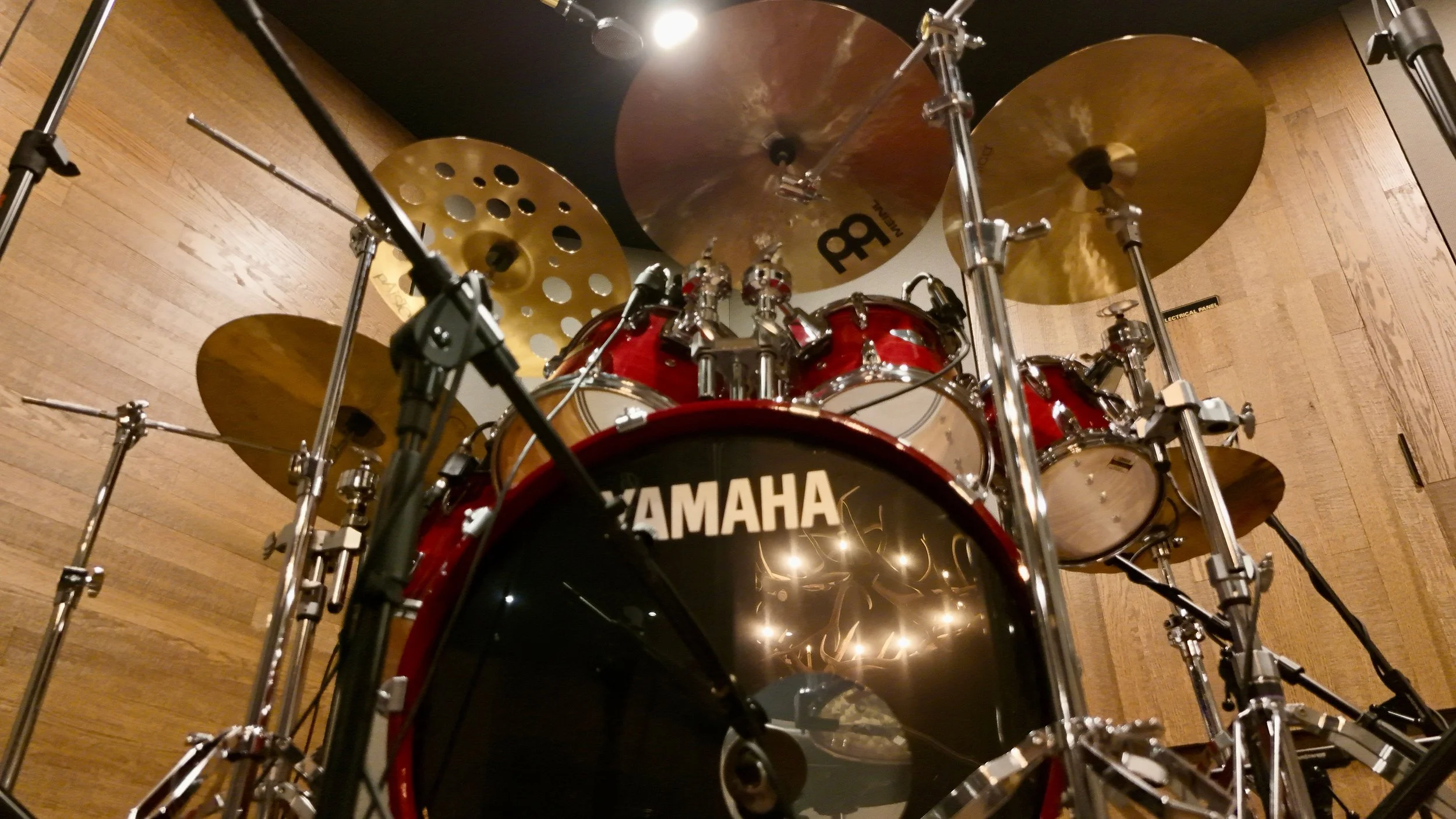 A red Yamaha drum set with cymbals, viewed from above, with a wooden ceiling in the background.