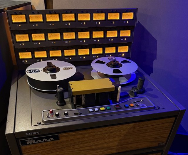 A vintage Sony Metro cassette tape recorder with two open reel tapes and a control panel with colorful buttons, knobs, and switches, used for audio recording and playback.