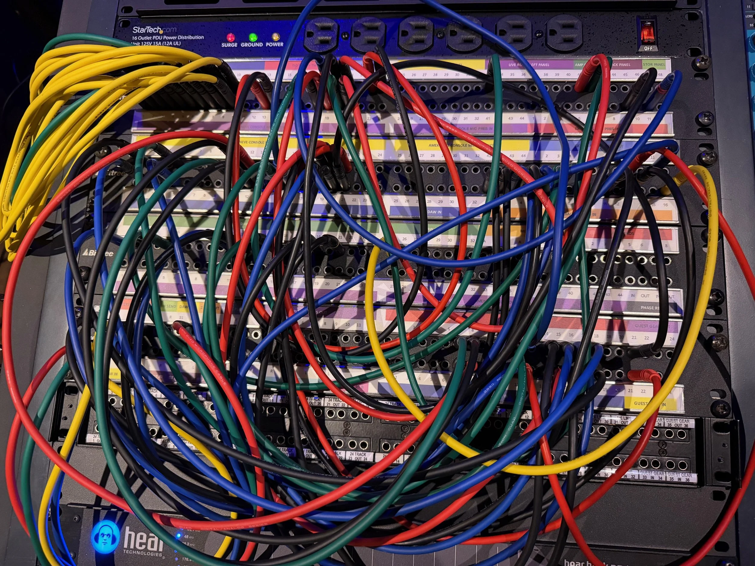 A server rack with multiple colored network cables tangled and connected to various ports.