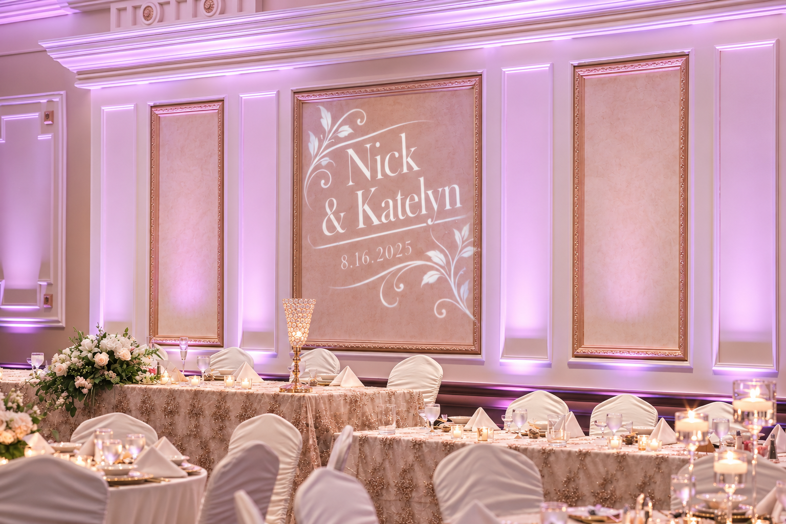 Purple uplighting and a custom monogram projected on the wall behind a wedding head table
