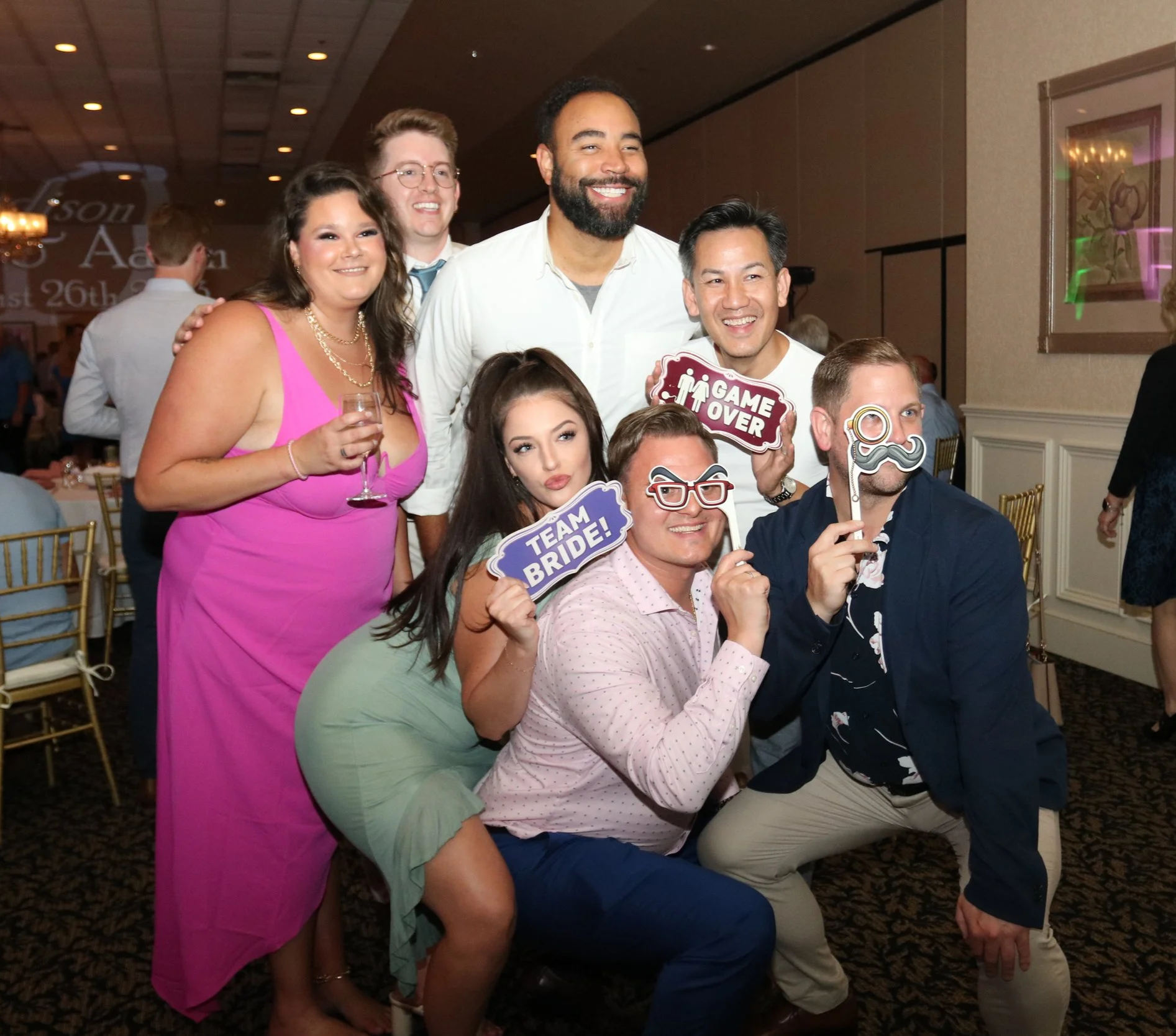 Wedding guests laughing and posing with props at a NightBeat photo booth