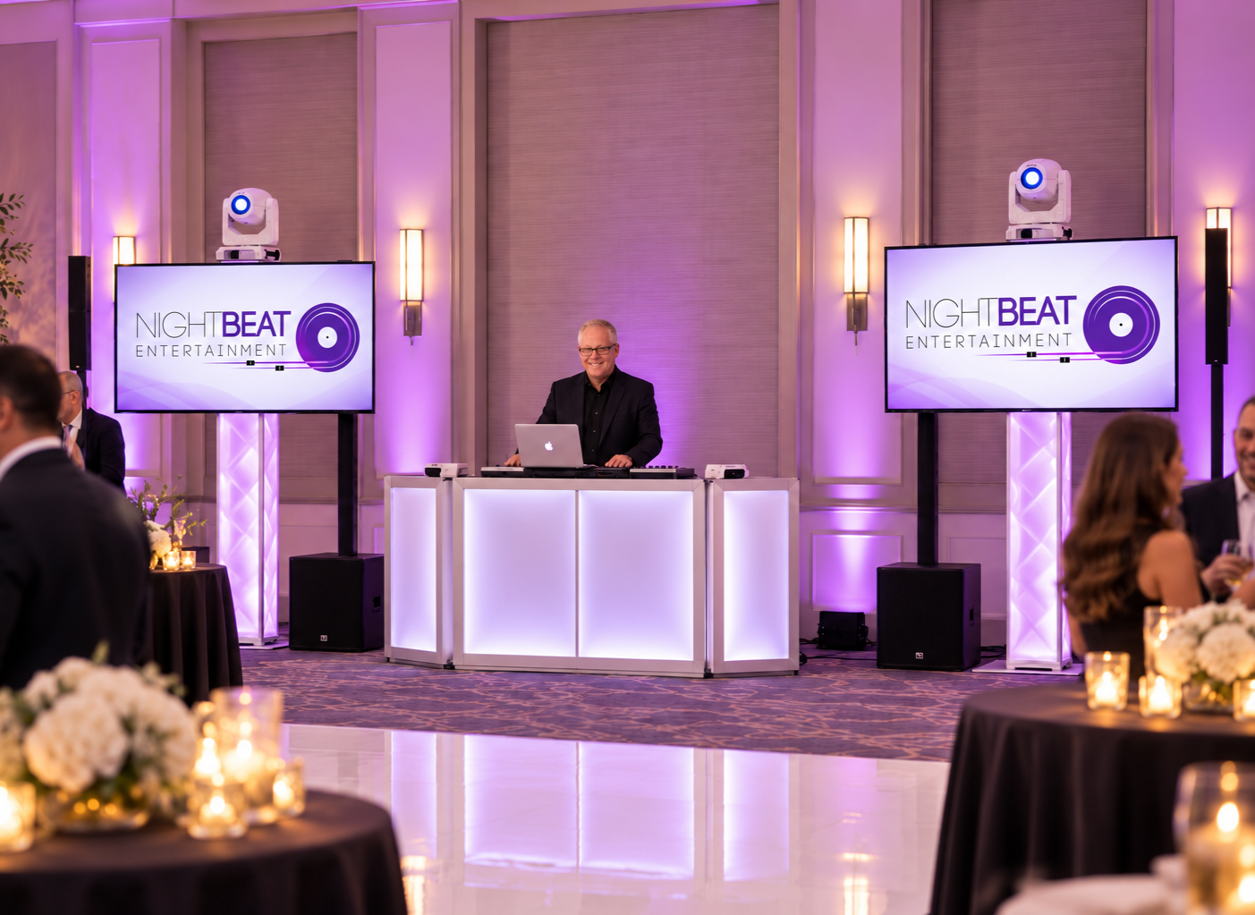 NightBeat Entertainment DJ booth with branded screens and purple uplighting at a corporate event