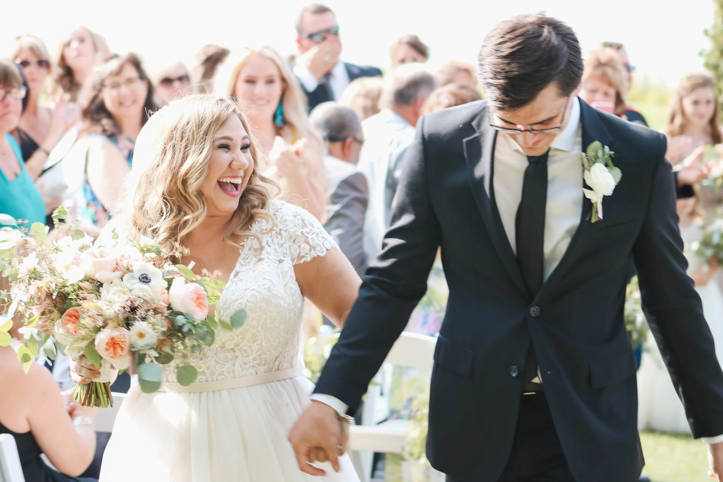 Bride and groom smiling as they walk back up the aisle after their wedding ceremony