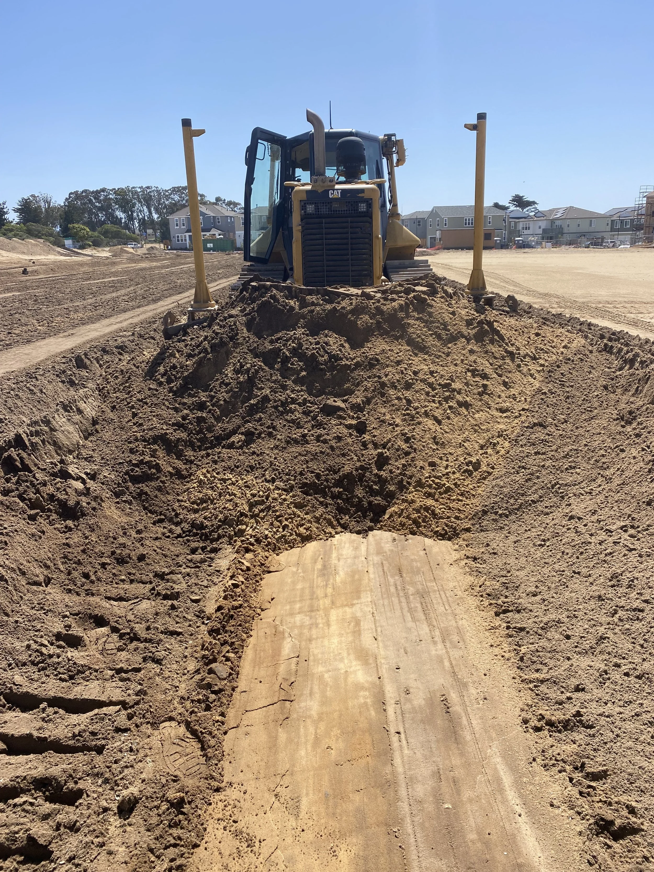dozer pushing cut into the fill for a pad certification
