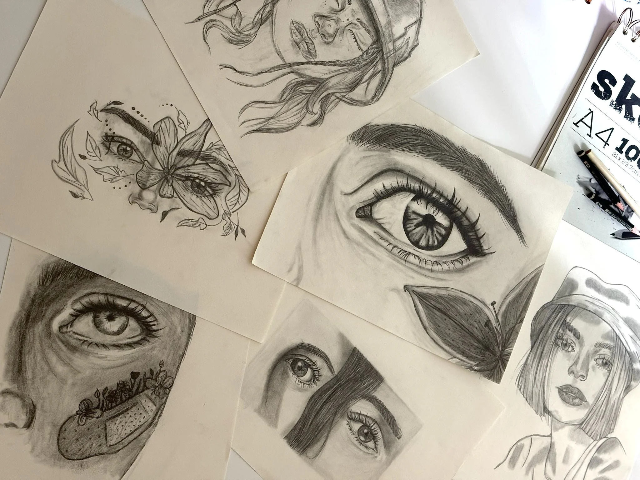 Verschiedene Bleistiftskizzen auf Papier, mit Bleistift und Radiergummi.