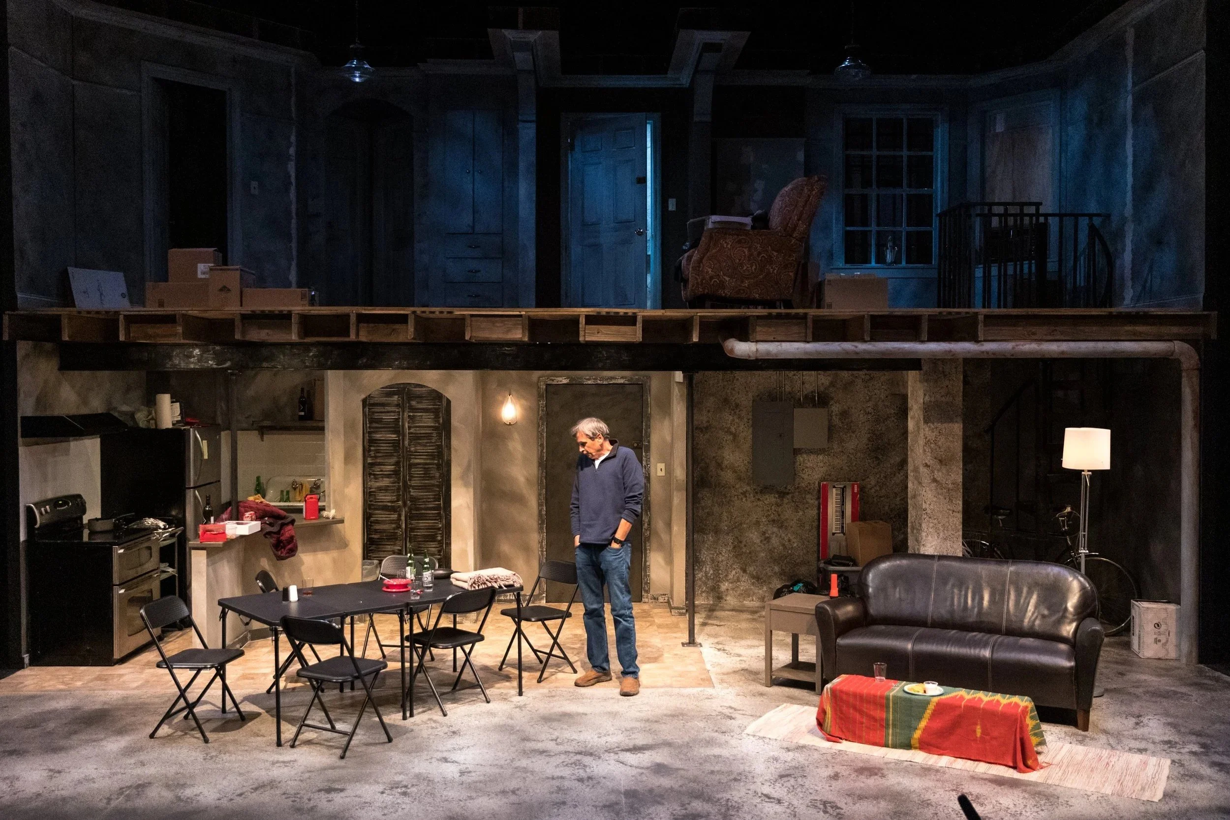 The Humans at Park Square Theatre, 2022: warm light downstairs contrasts with a cool blue upper floor. Lighting by Karin Olson.