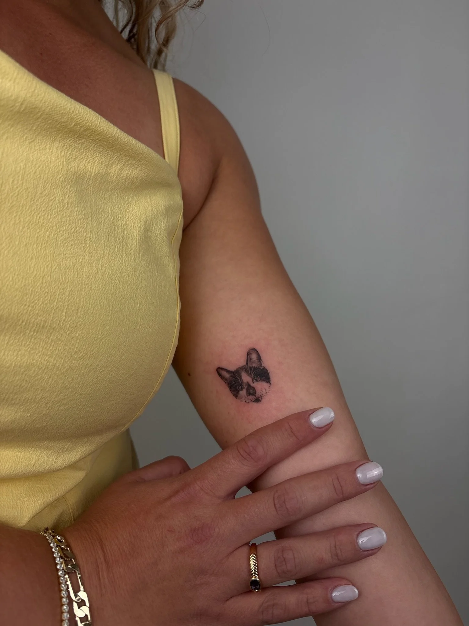 A personal micro realistic pet portrait of clients cat on their inner arm.