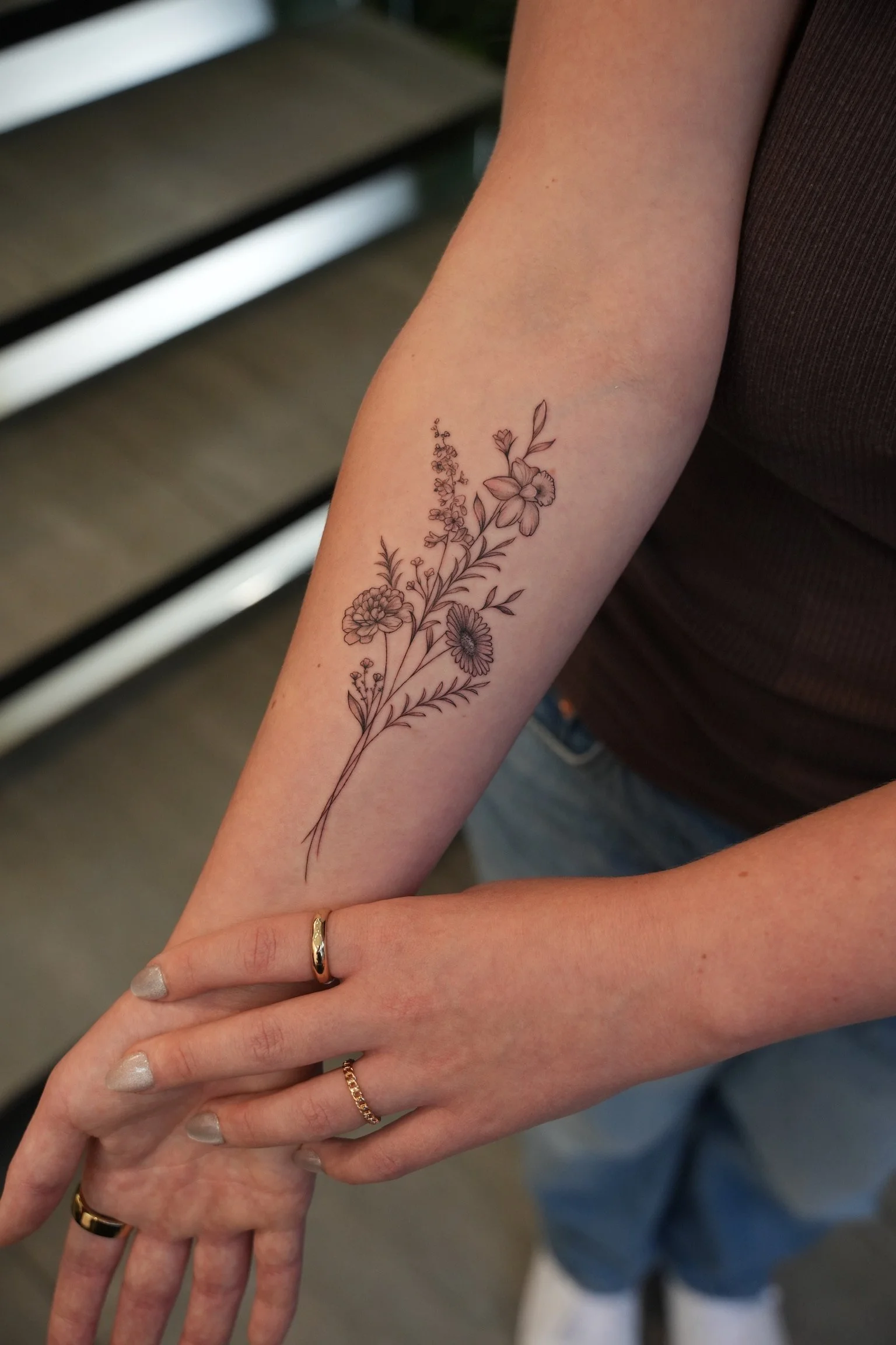 Close-up of a floral tattoo on the forearm, adorned with twine.