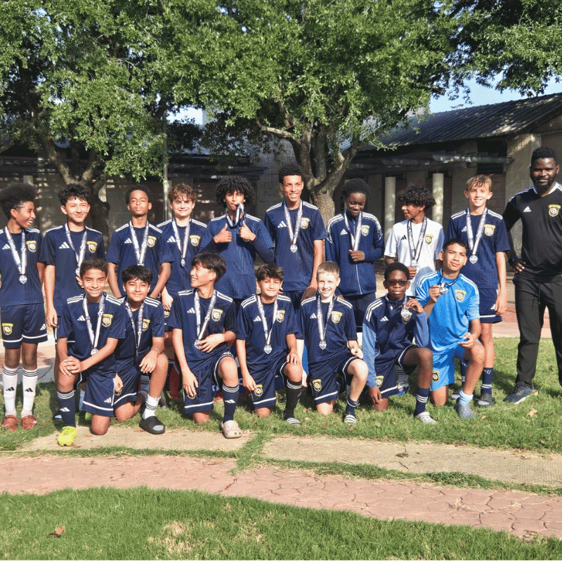 Boys select soccer team with medals and their coach outdoors