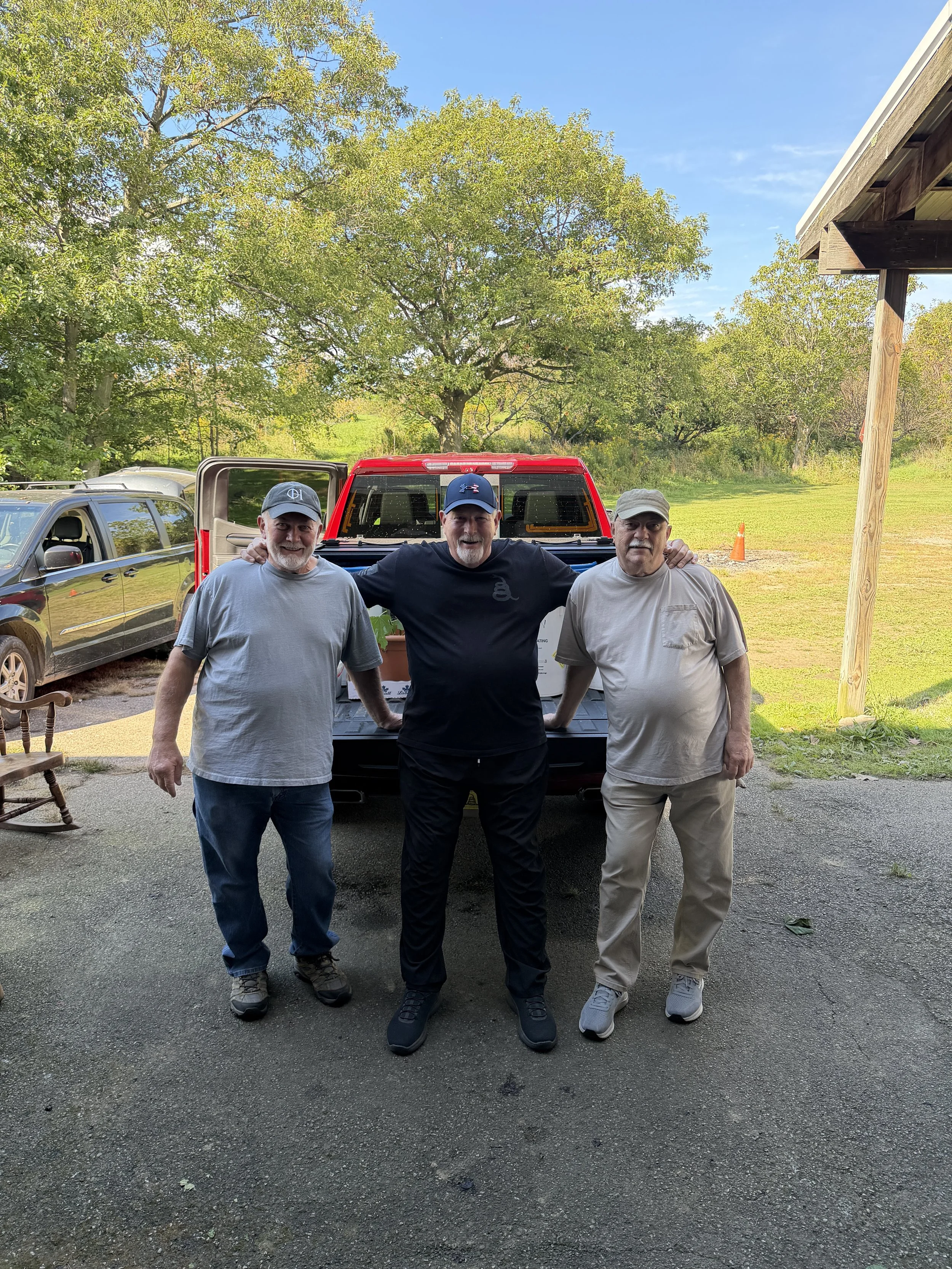three men with pickup truck group photo outdoors.jpeg