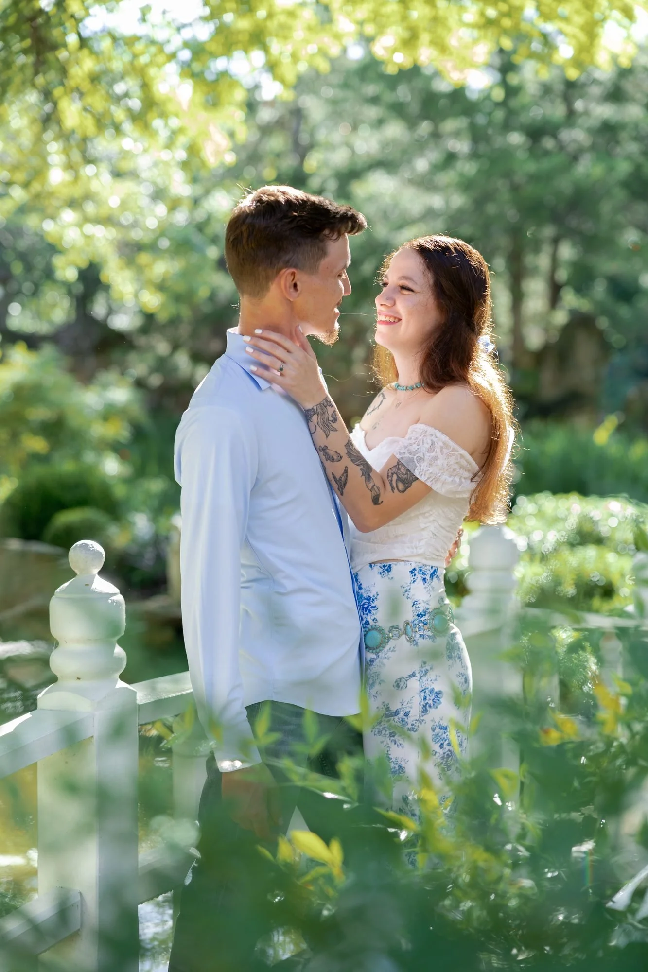 Couple embracing on a garden bridge, photographed by a Fort Worth engagement photographer