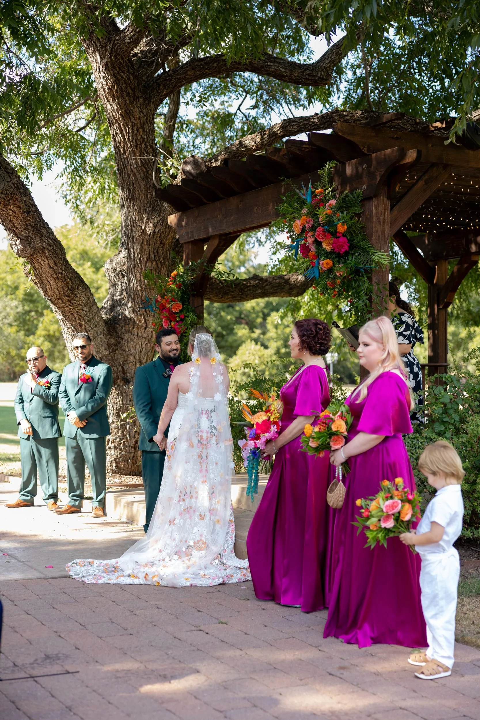Outdoor wedding ceremony under a large oak tree at The Orchard in Azle, Texas
