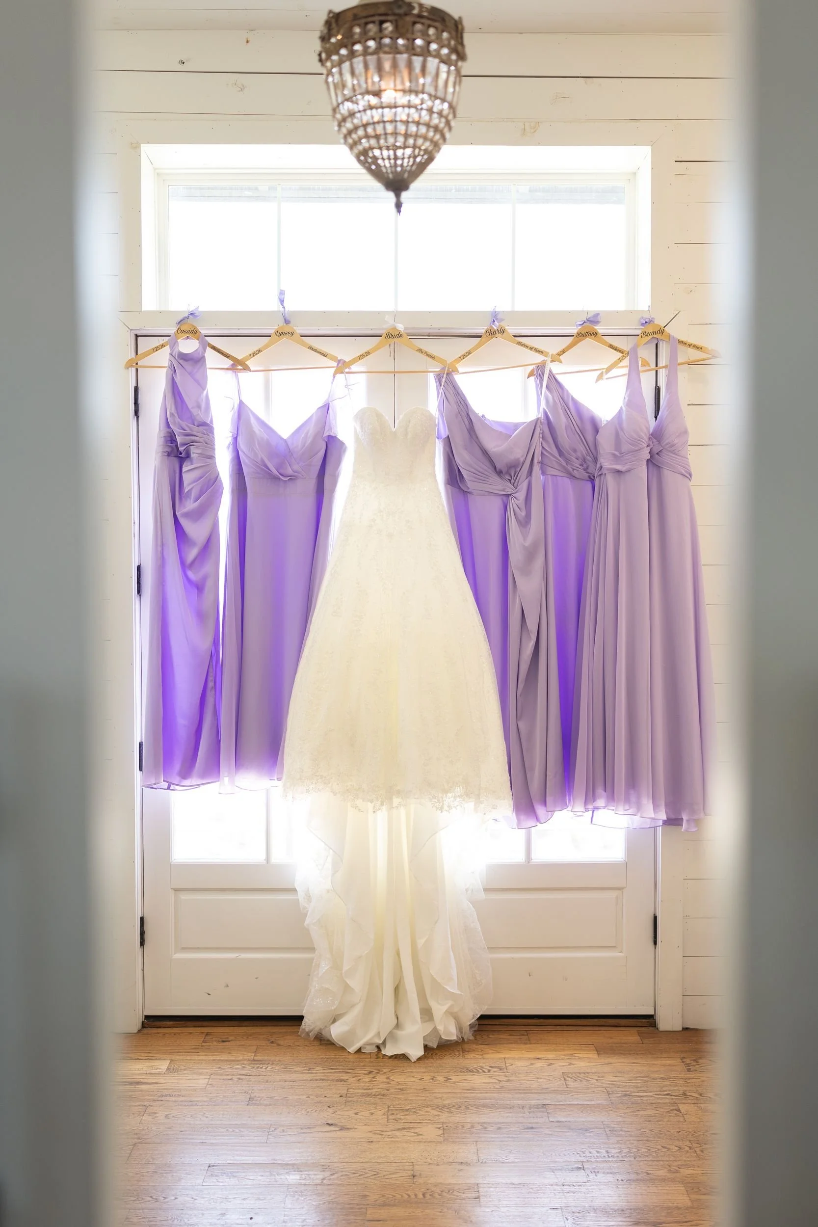 Lavender bridesmaid dresses hanging in the bridal suite window at The Barn at Paradise Place