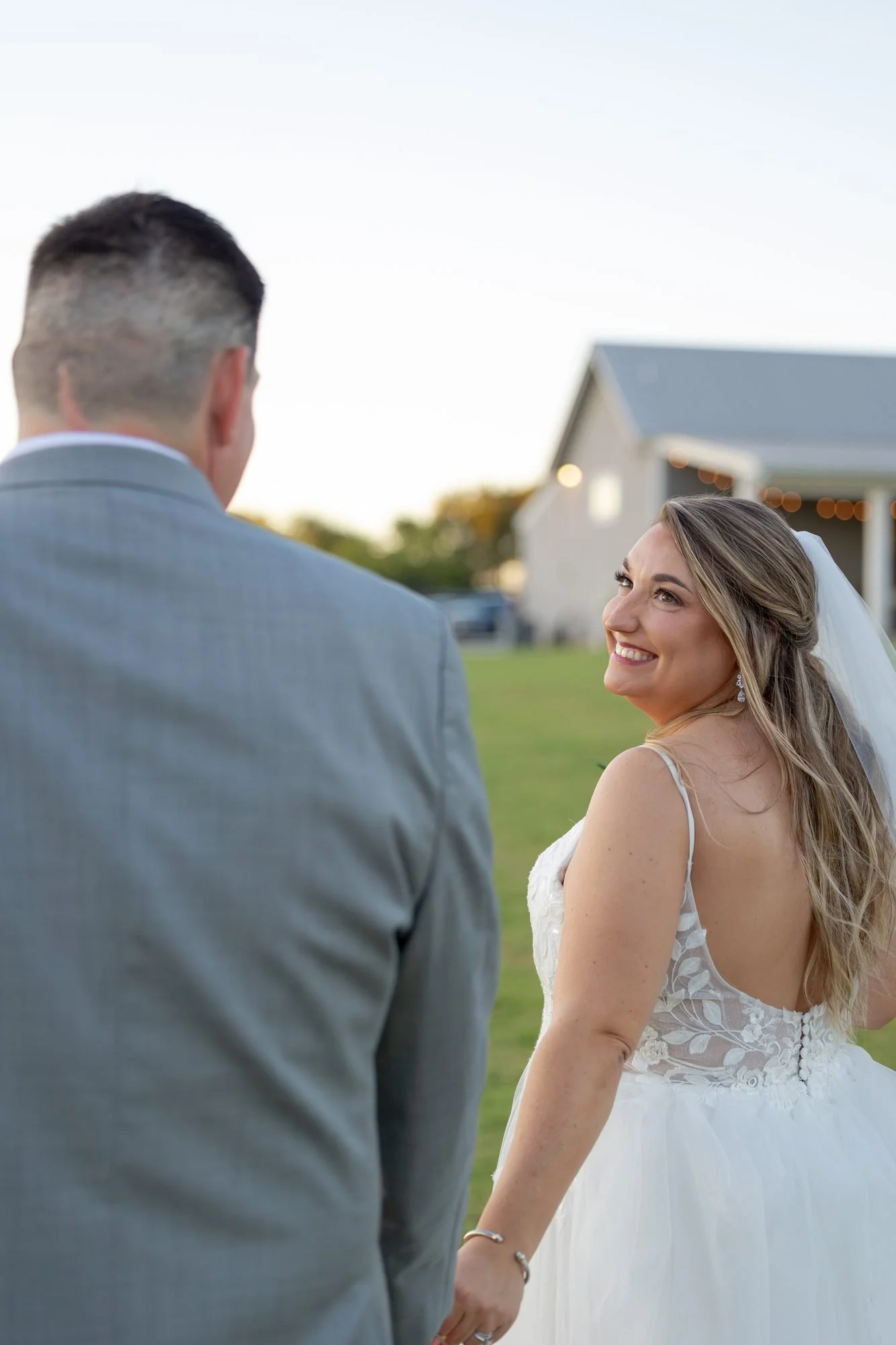 Bride smiling at her groom during a golden hour wedding portrait