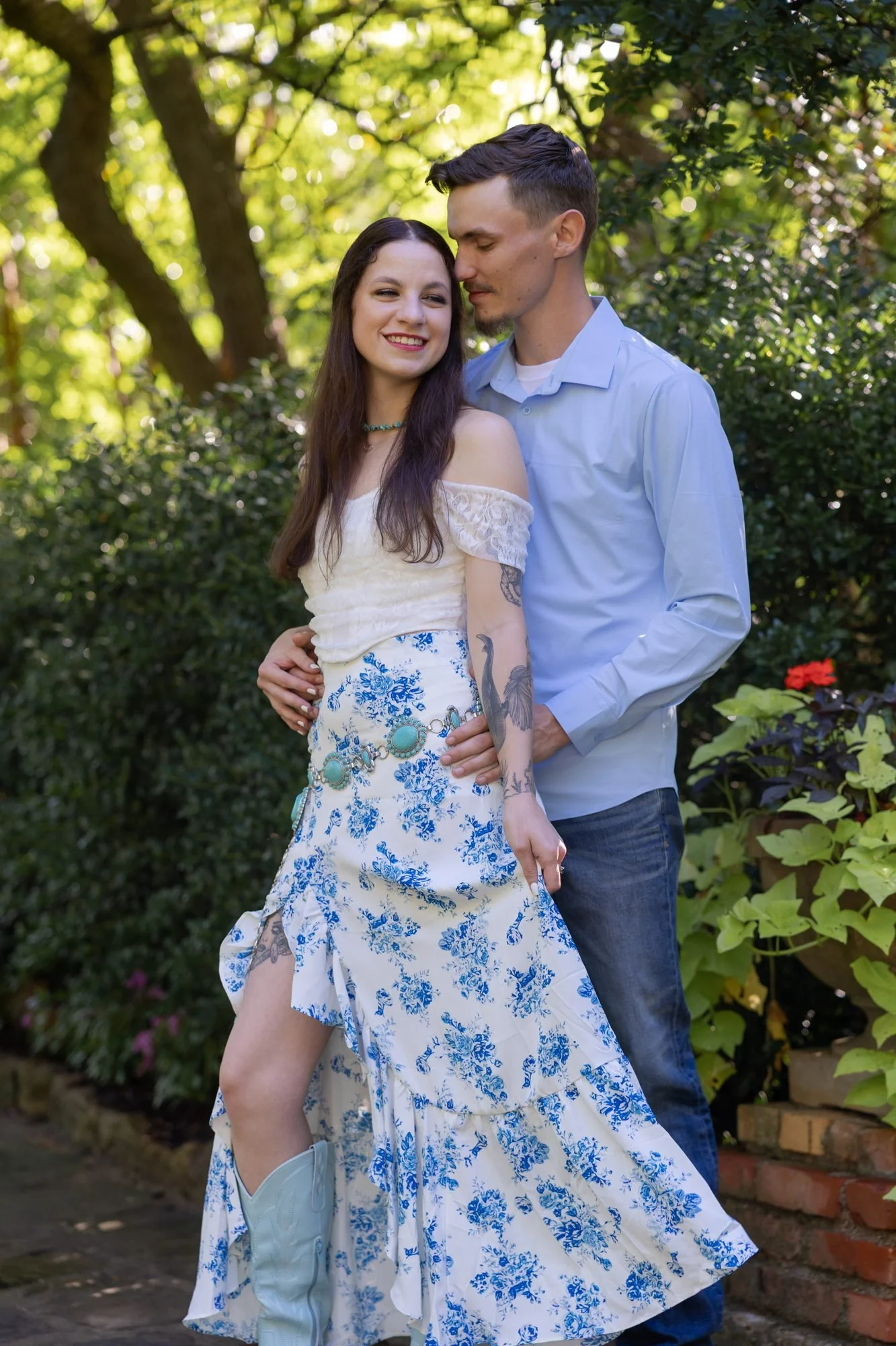 Couple embracing in a sunlit garden during a Fort Worth engagement session