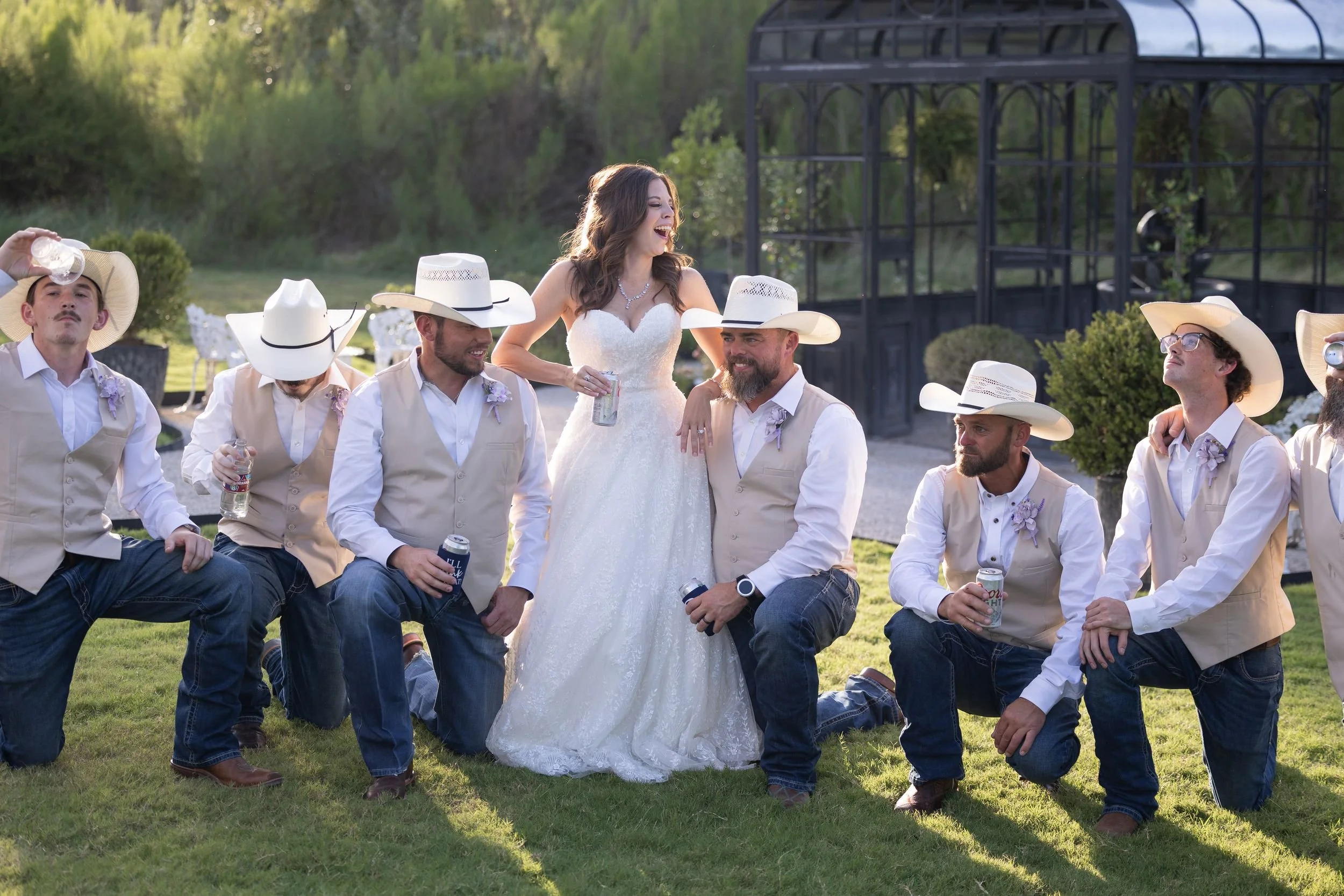 Wedding party with groomsmen in cowboy hats on the lawn at The Barn at Paradise Place