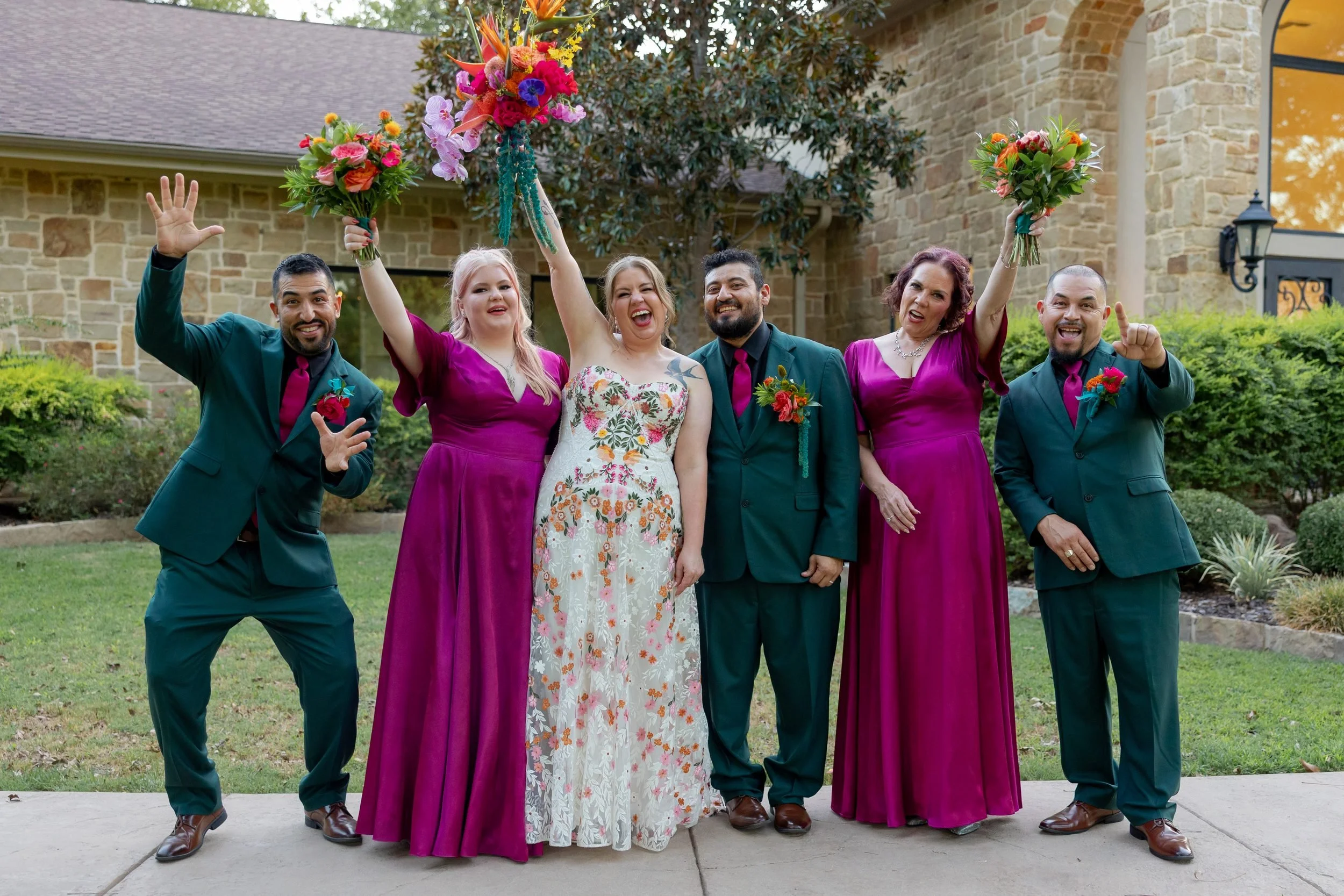 Carita and Miguel celebrating with their wedding party in magenta and teal at The Orchard in Azle