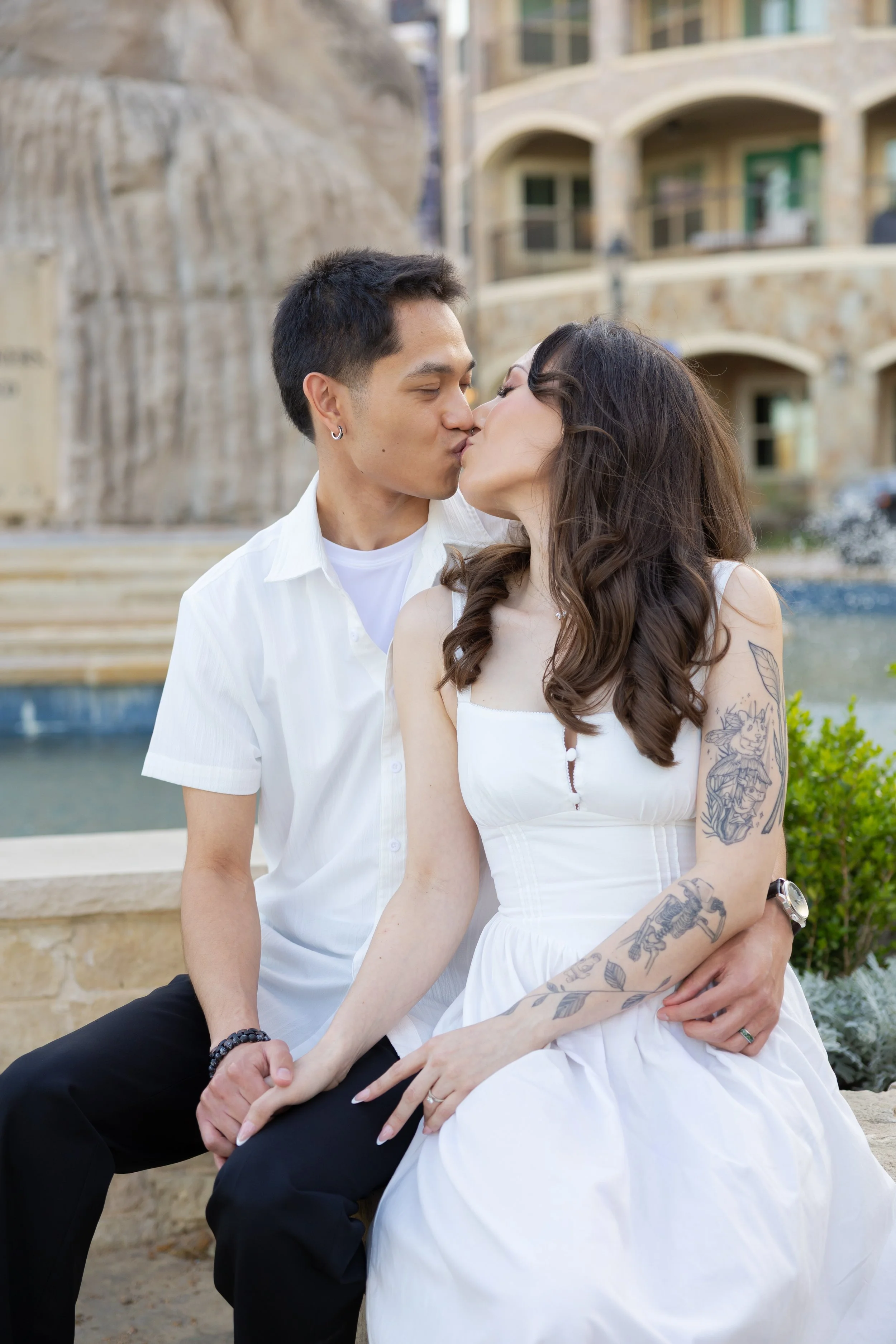 Couple kissing in front of historic architecture during a downtown engagement session