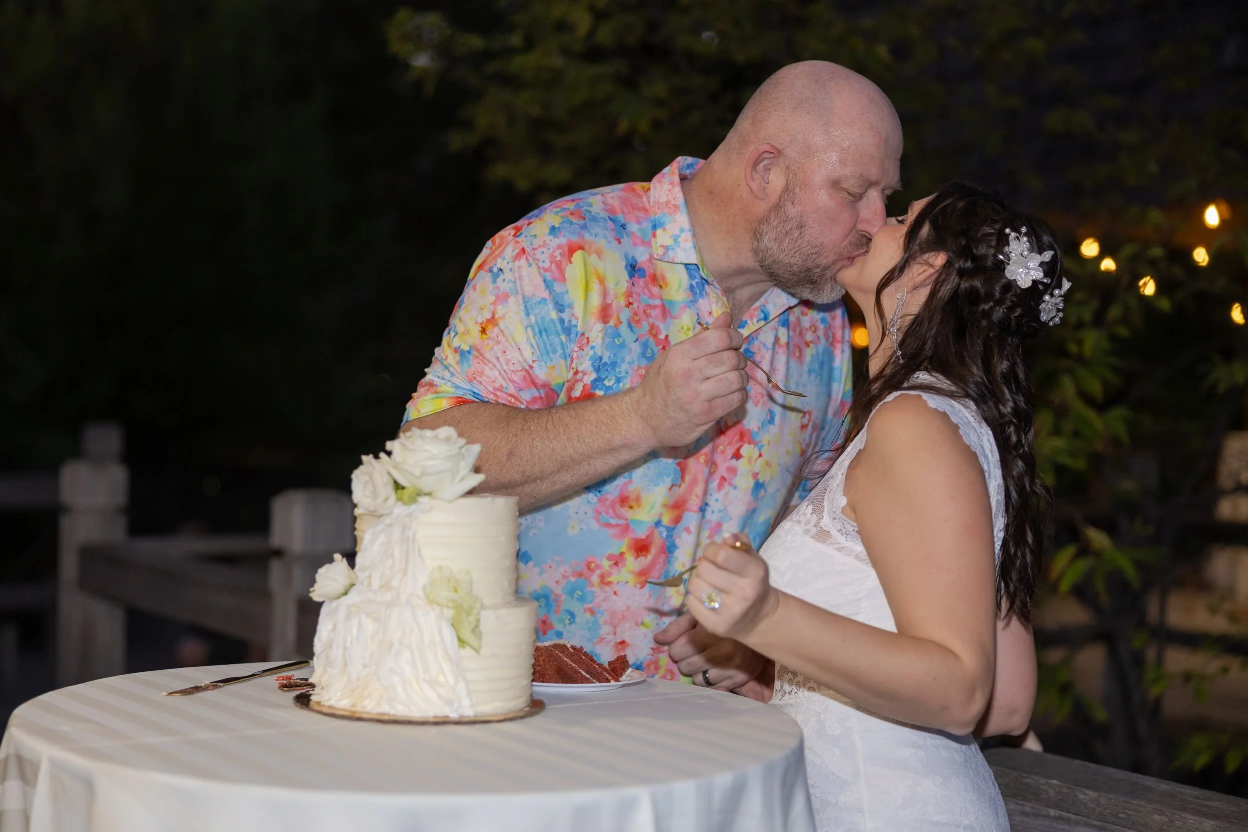 Lydia and Ryan cutting their wedding cake at their nighttime garden reception