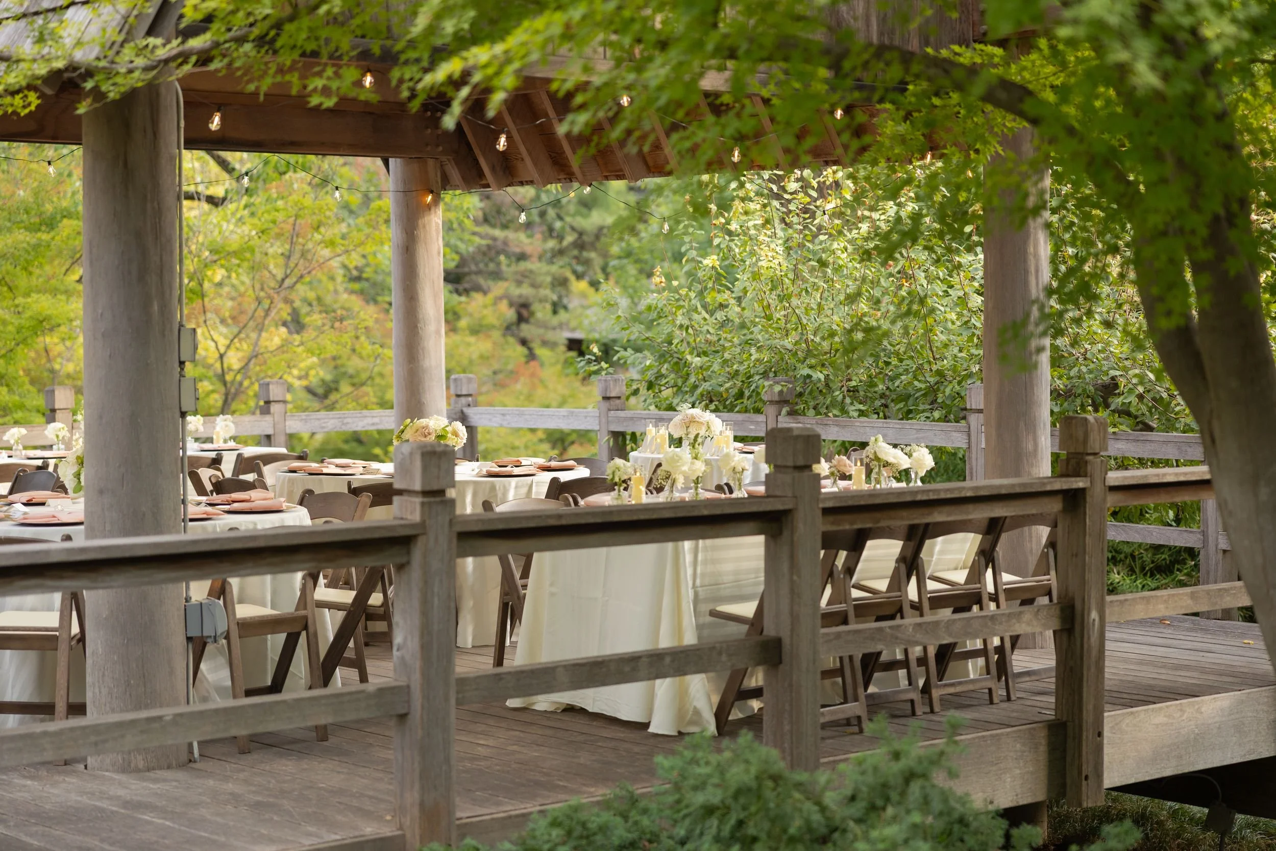 Outdoor wedding reception seating under a wooden pergola at the Fort Worth Japanese Garden