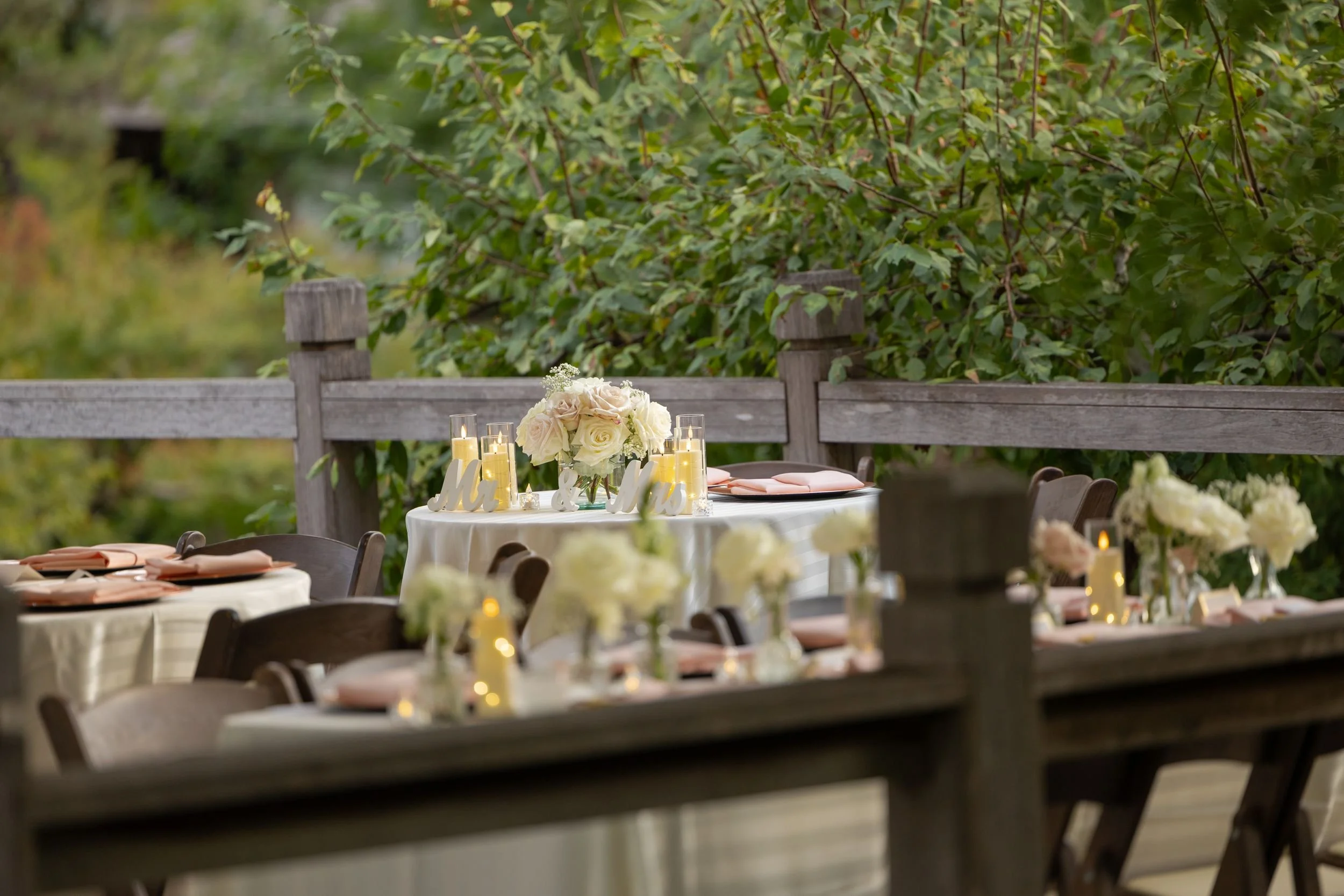 Reception tables with white floral centerpieces on the deck at the Fort Worth Japanese Garden