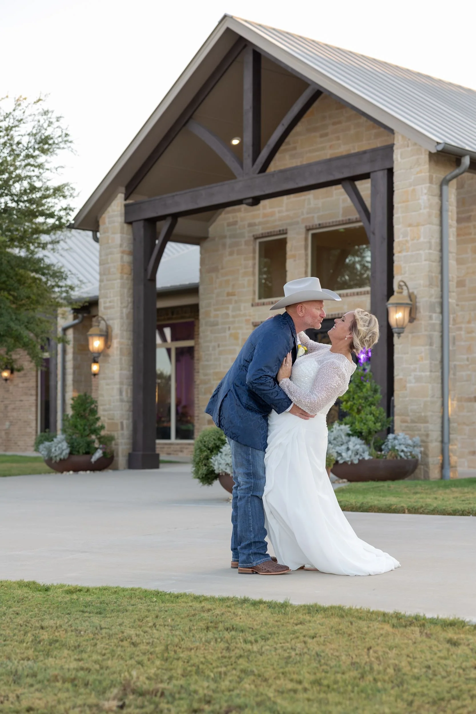 Bride and groom kissing in front of the event center at Dove Ridge Vineyard