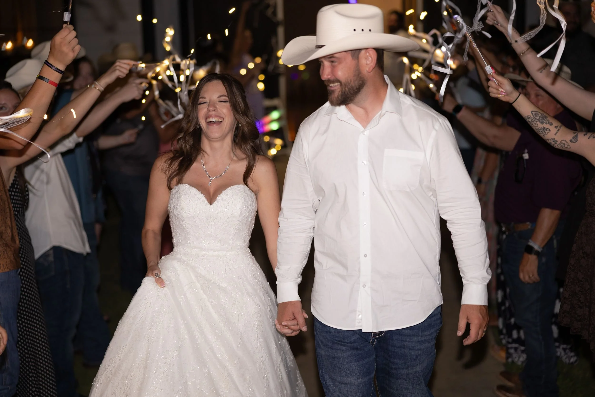 Groomsmen in cowboy hats celebrating with glow sticks during the send-off