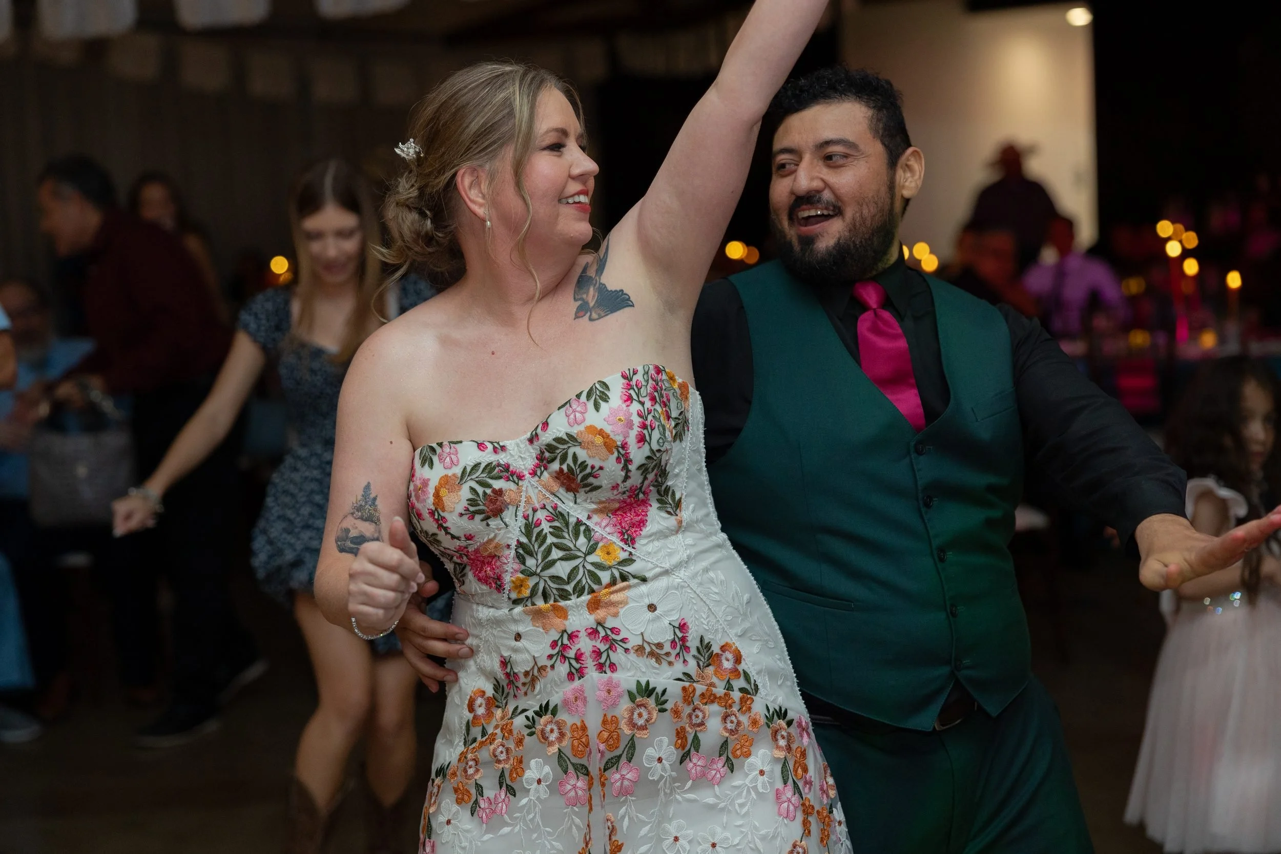 Bride and groom dancing with their arms up at their Azle wedding reception