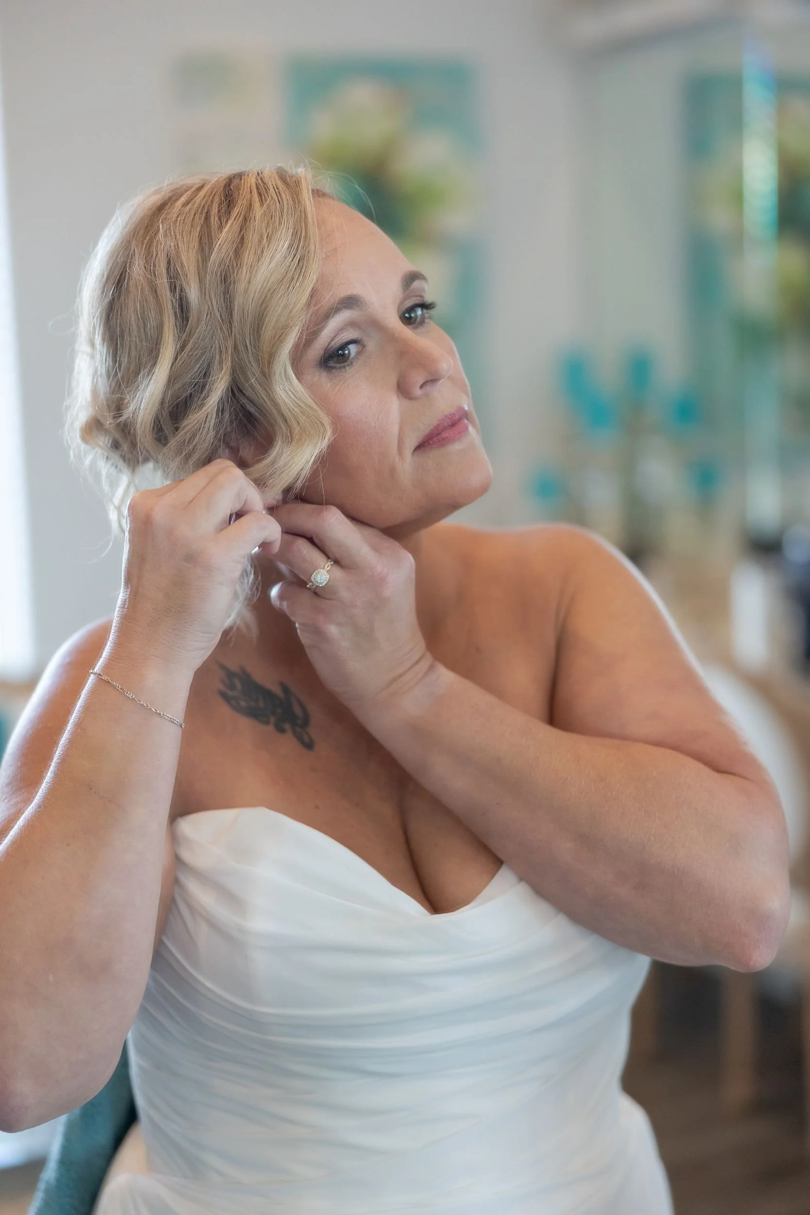 Bride putting on her earrings while getting ready at Dove Ridge Vineyard