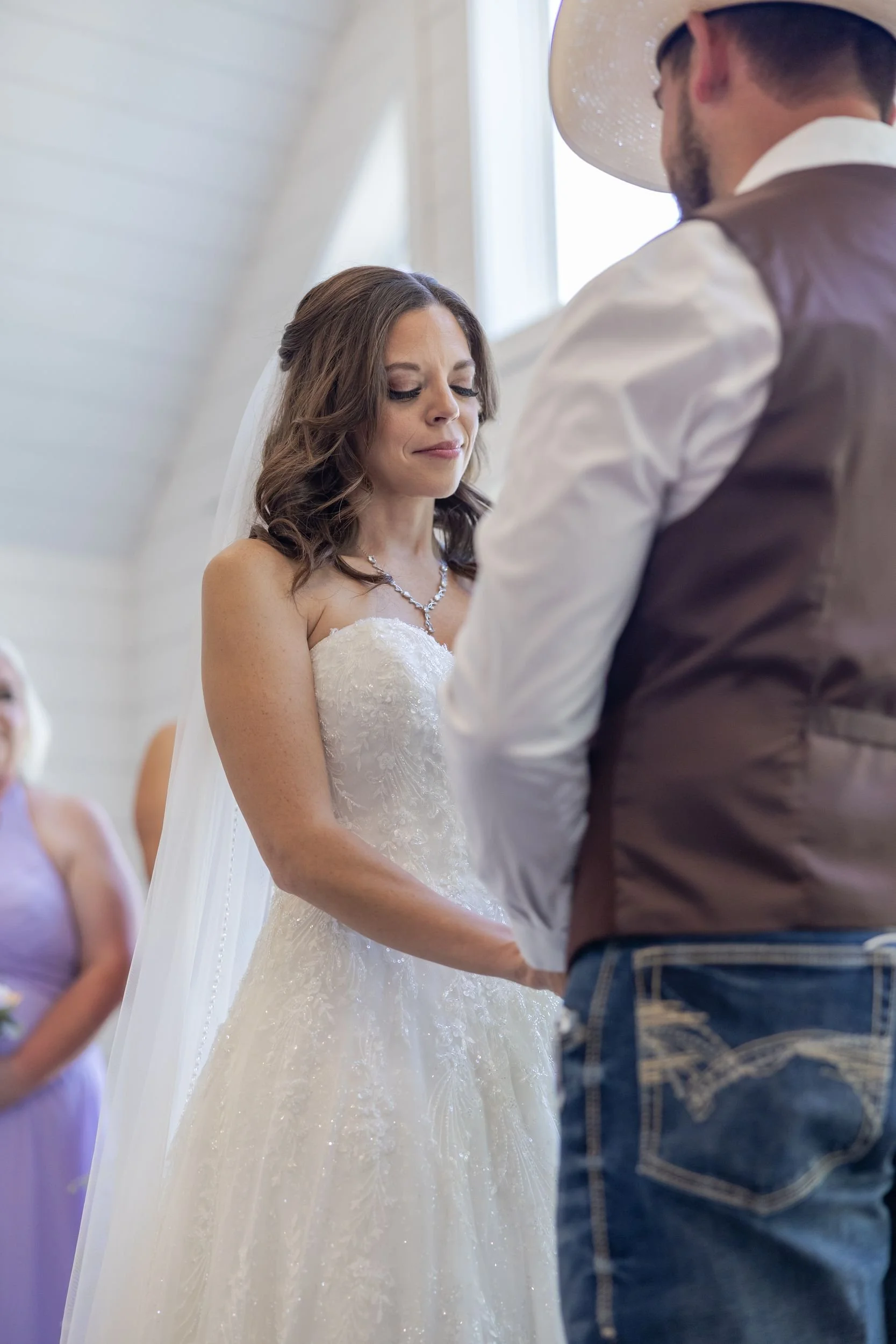 Heather and Geffrey holding hands during their vows at The Barn at Paradise Place