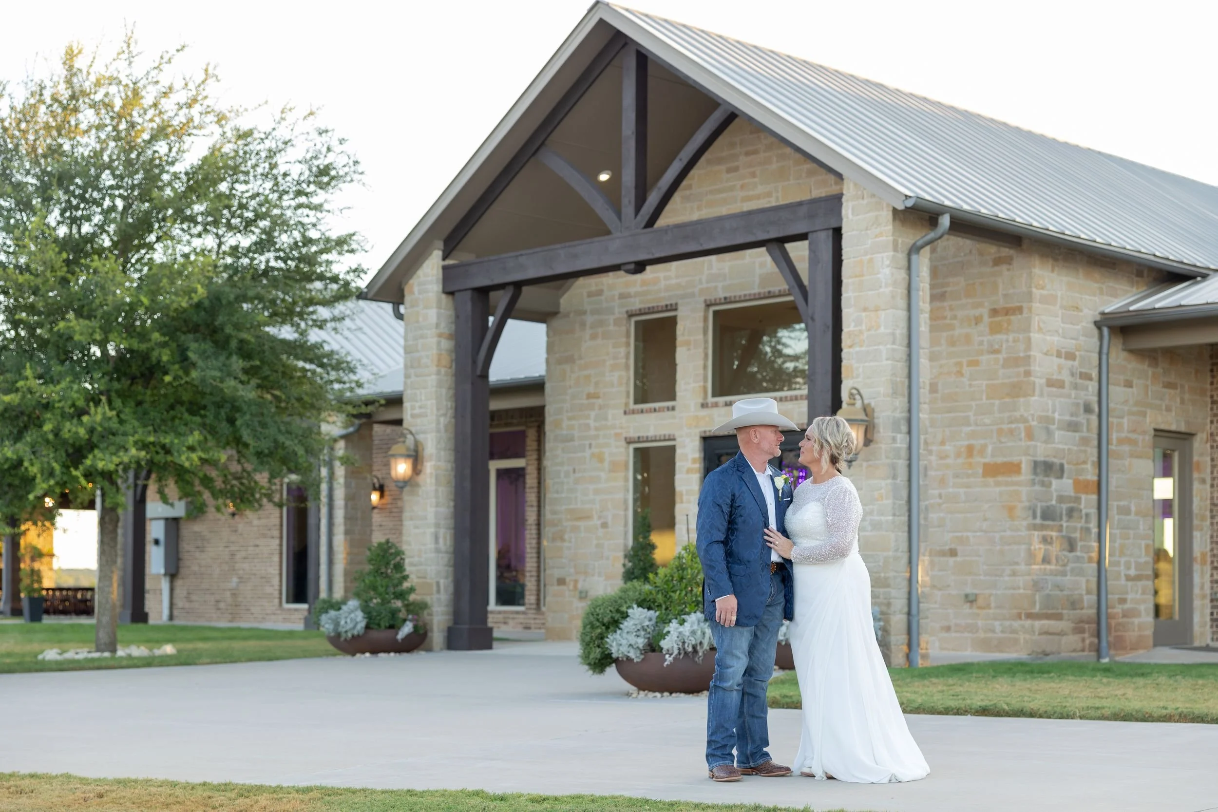 Lacey and Jason in front of the stone event center at Dove Ridge Vineyard in Weatherford