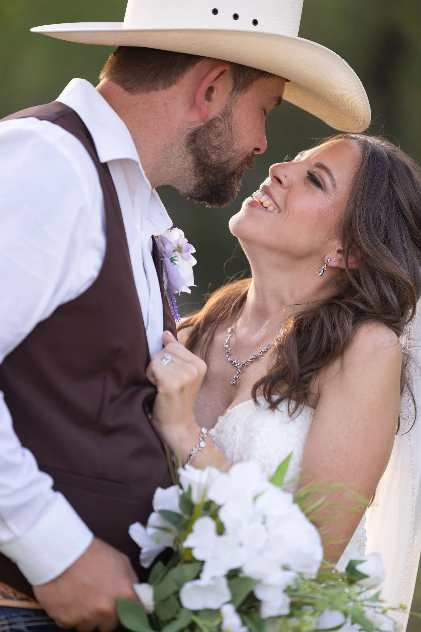 Cowboy groom and bride sharing a close moment during Weatherford wedding portraits