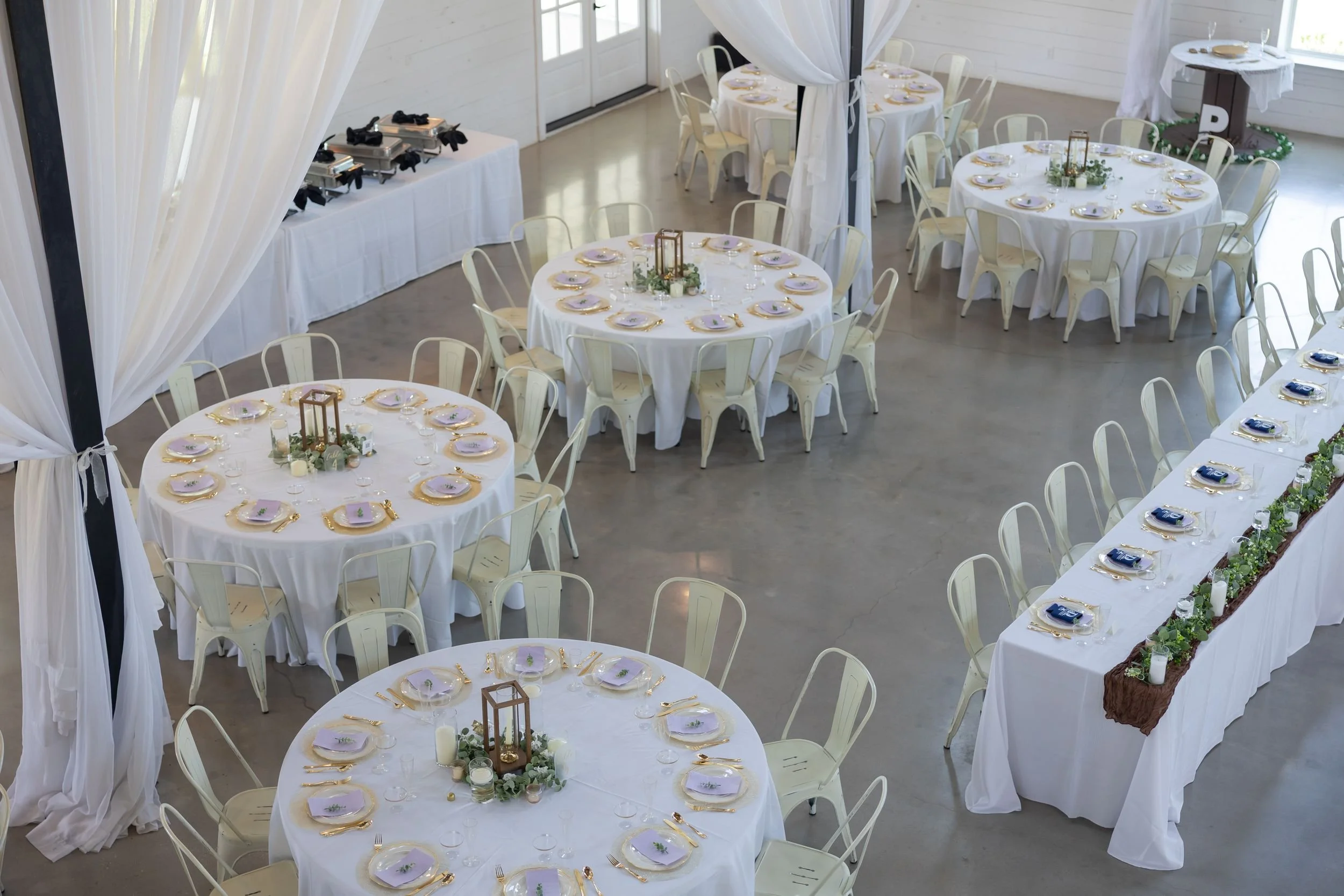 Reception hall set with round tables and white linens at The Barn at Paradise Place