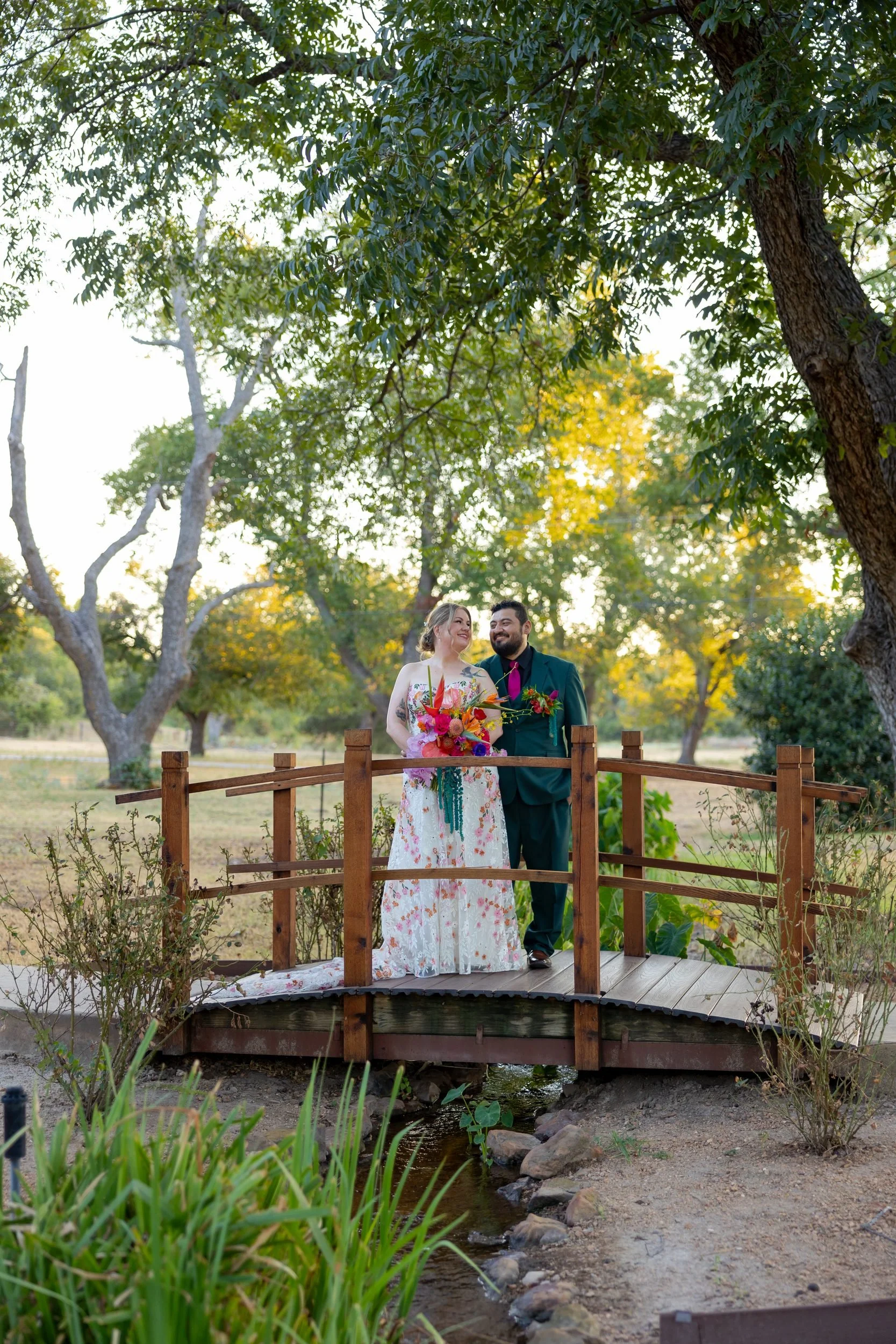 Bride and groom on a small wooden bridge at The Orchard wedding venue