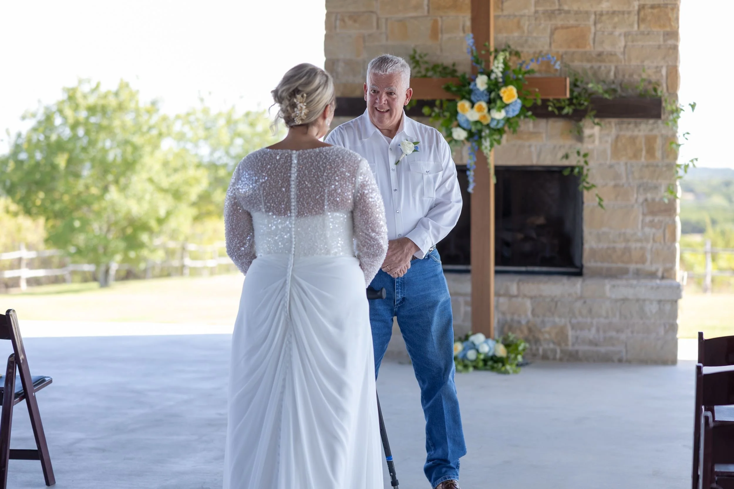 Bride walking toward the stone fireplace on the patio at Dove Ridge Vineyard