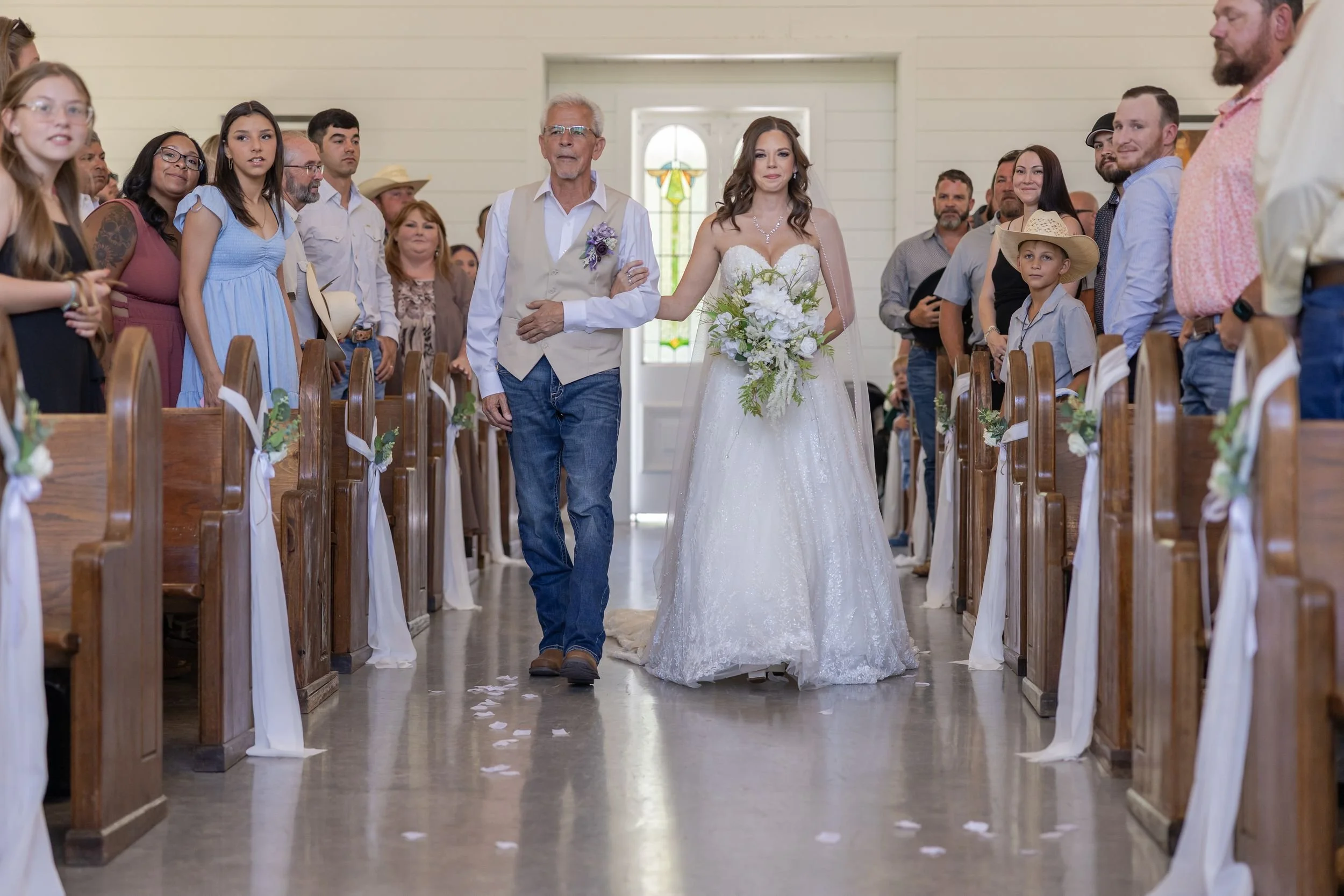 Heather walking down the aisle with her father in the chapel at The Barn at Paradise Place