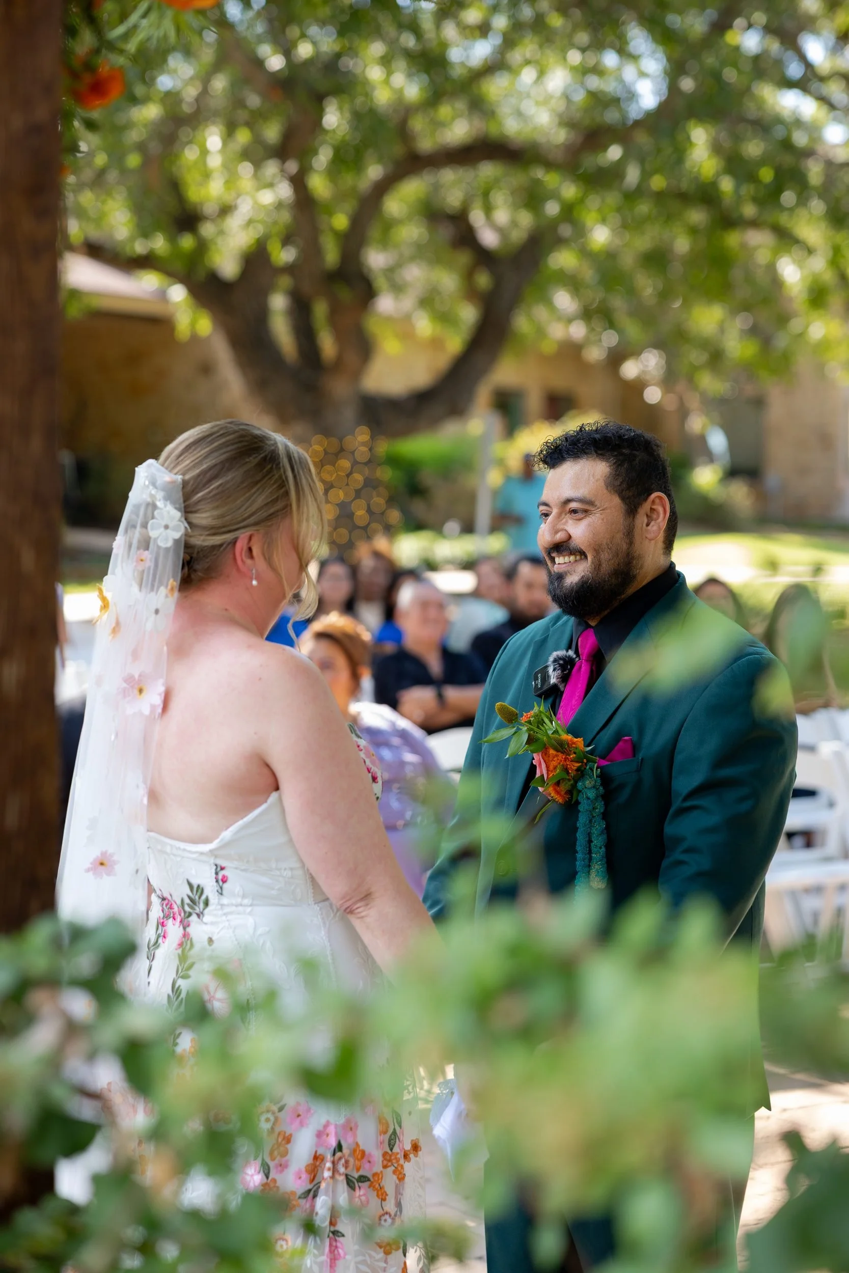 Carita and Miguel exchanging vows under the trees at The Orchard in Azle