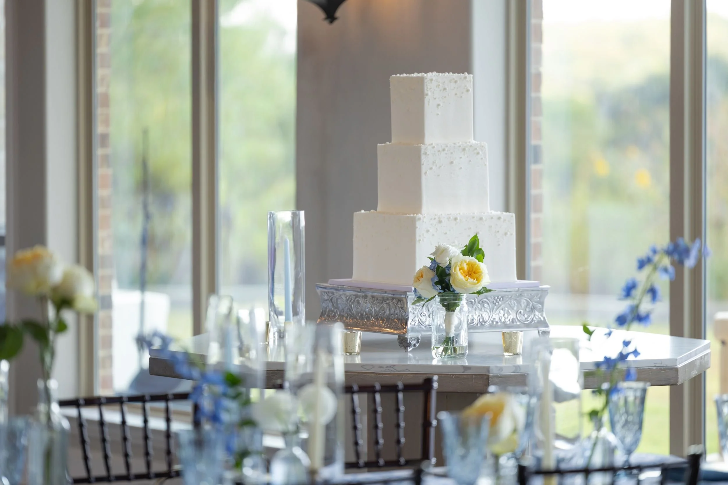 Reception tables set with glassware and blue accents at Dove Ridge Vineyard