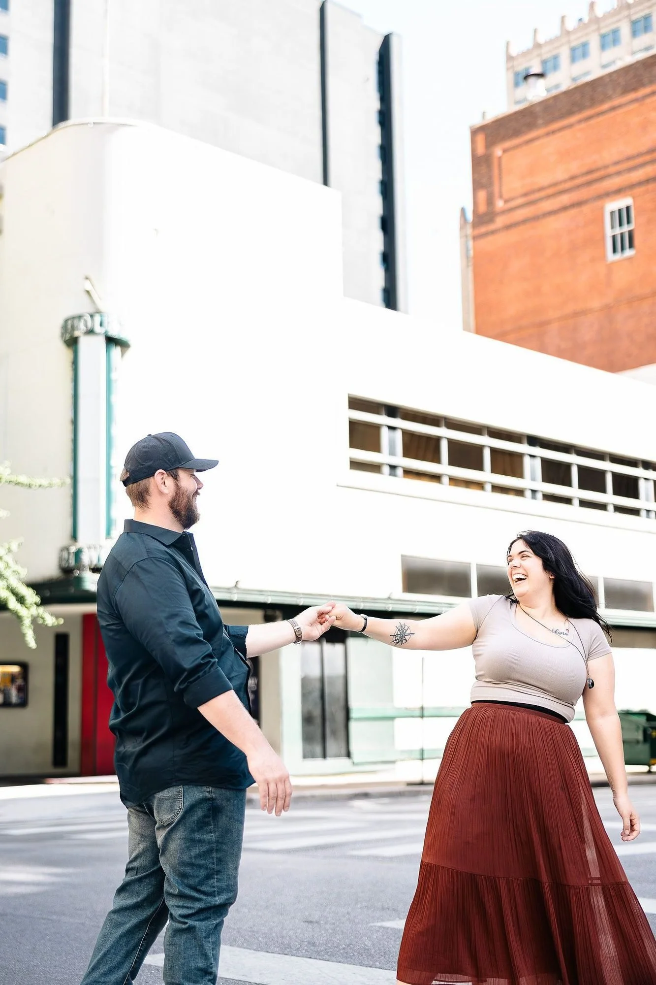 Husband-and-wife wedding photographers Dani and Jordan dancing on a street in Fort Worth, TX