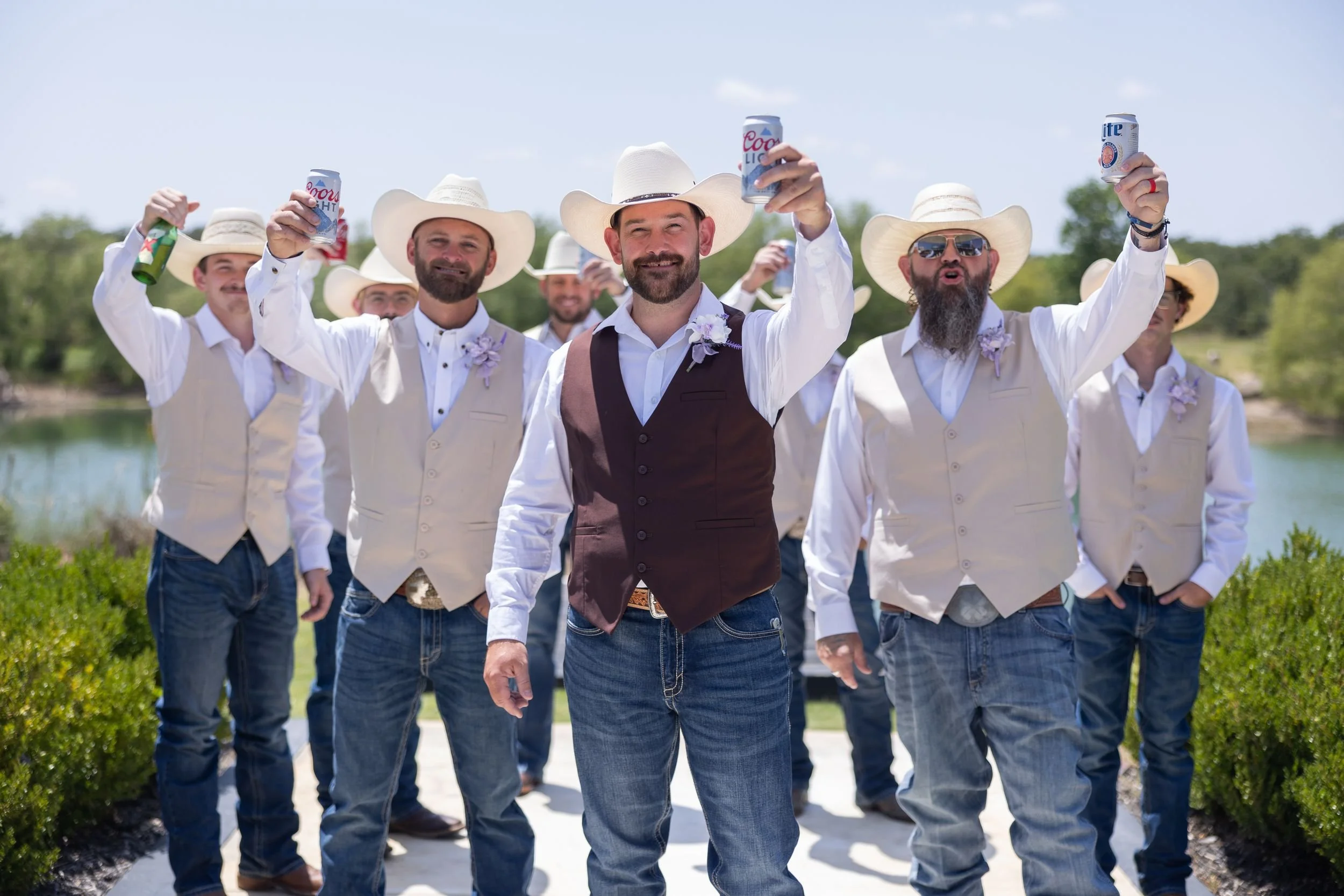 Groomsmen in cowboy hats and vests cheering with the groom in Weatherford, Texas